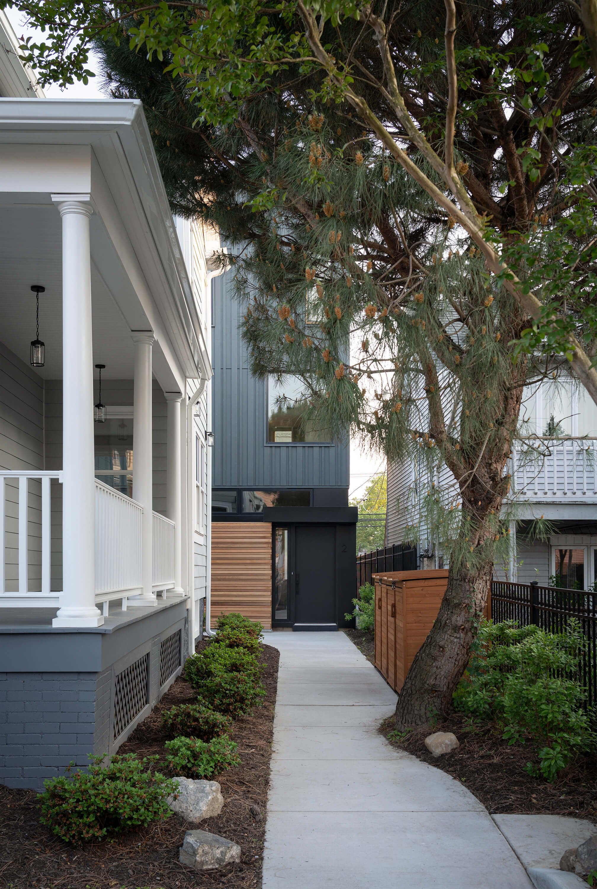 Exterior entry of townhouse behind historic house in Jersey City by Behin Ha Studio highlighting the relationship between preserved structure and new construction.
