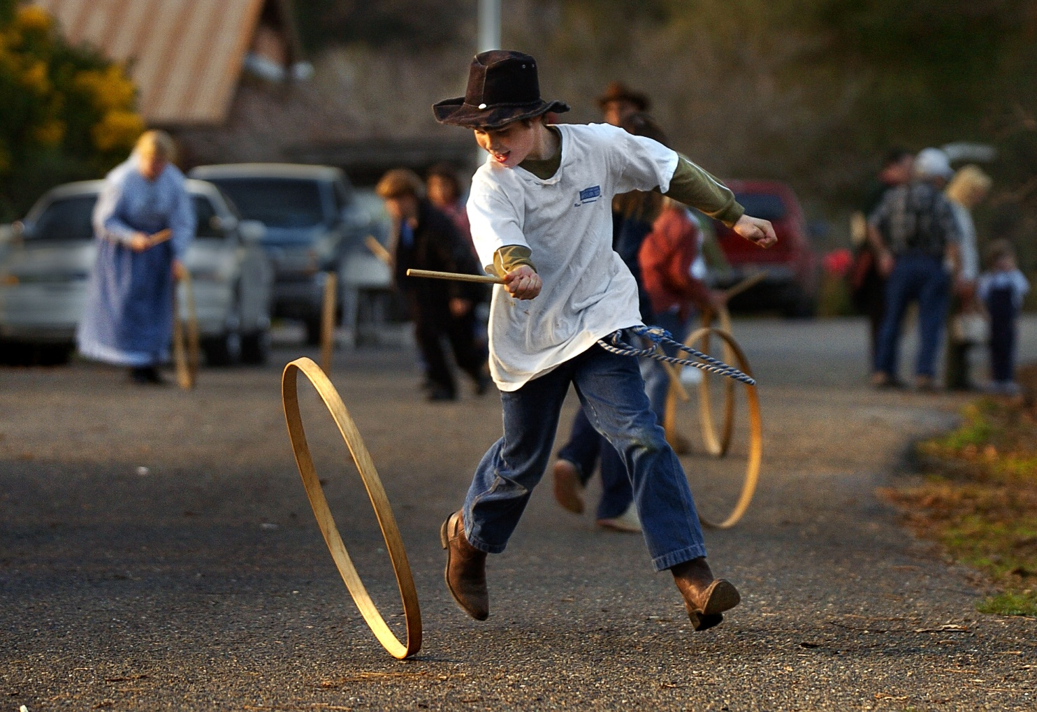 Philip Cowdery 9 rolls a wooden hoop down the road at the 'Christmas In Coloma' festival at the Marshall Gold Discovery State Park in Coloma on Sunday December 12, 2004.