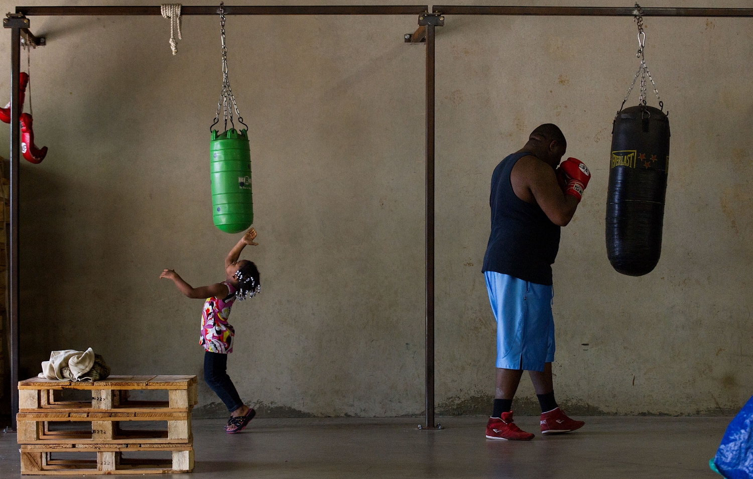 Ja'Niya Haley 3, left, mimics her father Cassius Haley as he works out at Main Event Mateen Boxing Club in Sacramento on Thursday, June 16, 2011.