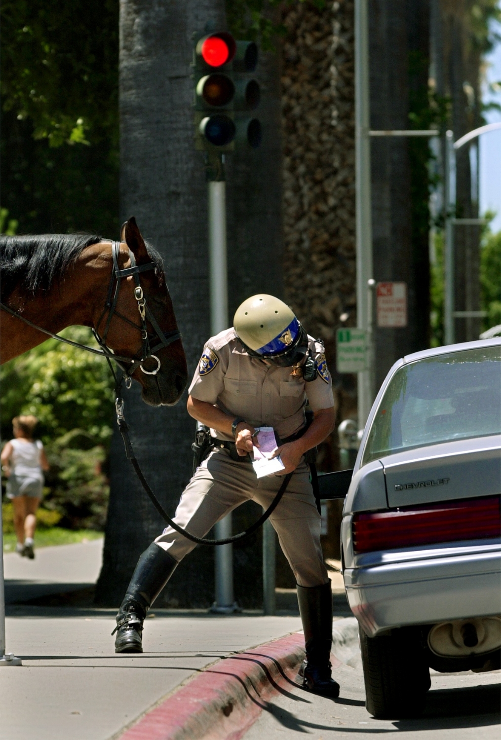  CHP Officer Tony Pineiro issues a traffic citation to a motorist who was driving on L street near the State Capitol in Sacramento on Thursday July 3, 2003. Pineiro pulled the driver over from his patrol horse named "Bo." 