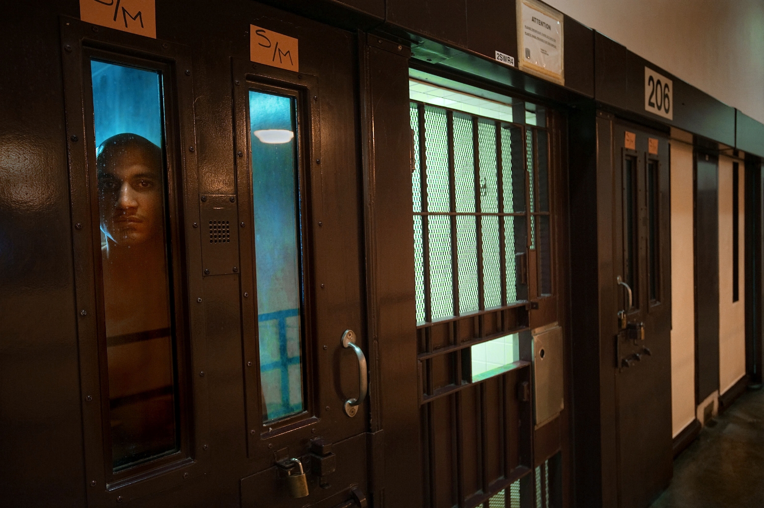  Prison inmate Joell Polanco, at left, peers from his cell in the behavior management unit at the Substance Abuse Treatment Facility in Corcoran on Thursday, March 25, 2010. 