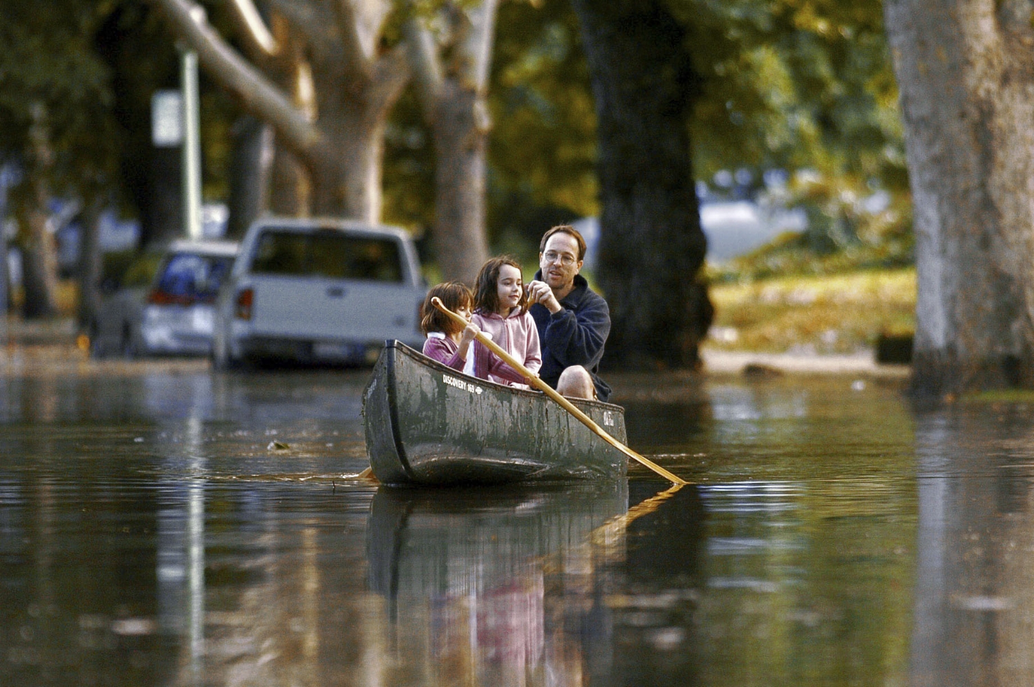  Lily Brown 5, left, her sister Emma Brown 6, and their father Doug Brown paddle a canoe up 38th Street near Folsom Blvd in Sacramento on Sunday September 19, 2004. Unexpected heavy rain flooded many parts of the midtown, and downtown areas of Sacram