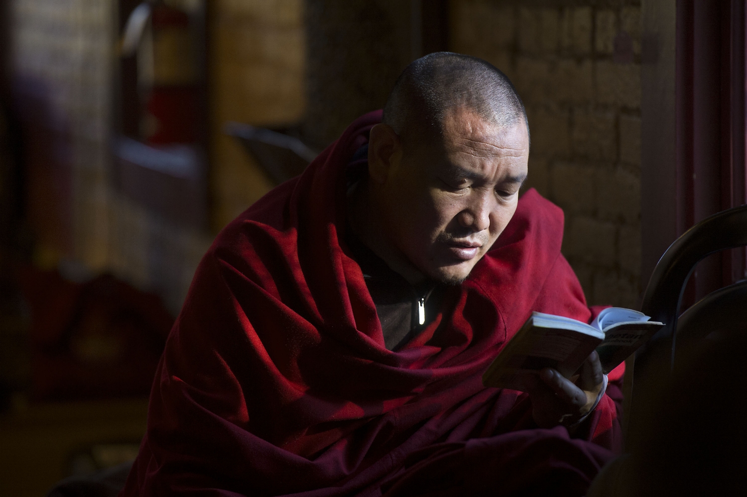 Gaden Shartse Tibetan monk Lobsang Ngawang reads while other monks work to create a sand mandala at the Cozmic Cafe in Placerville on Friday, January 3, 2014.
