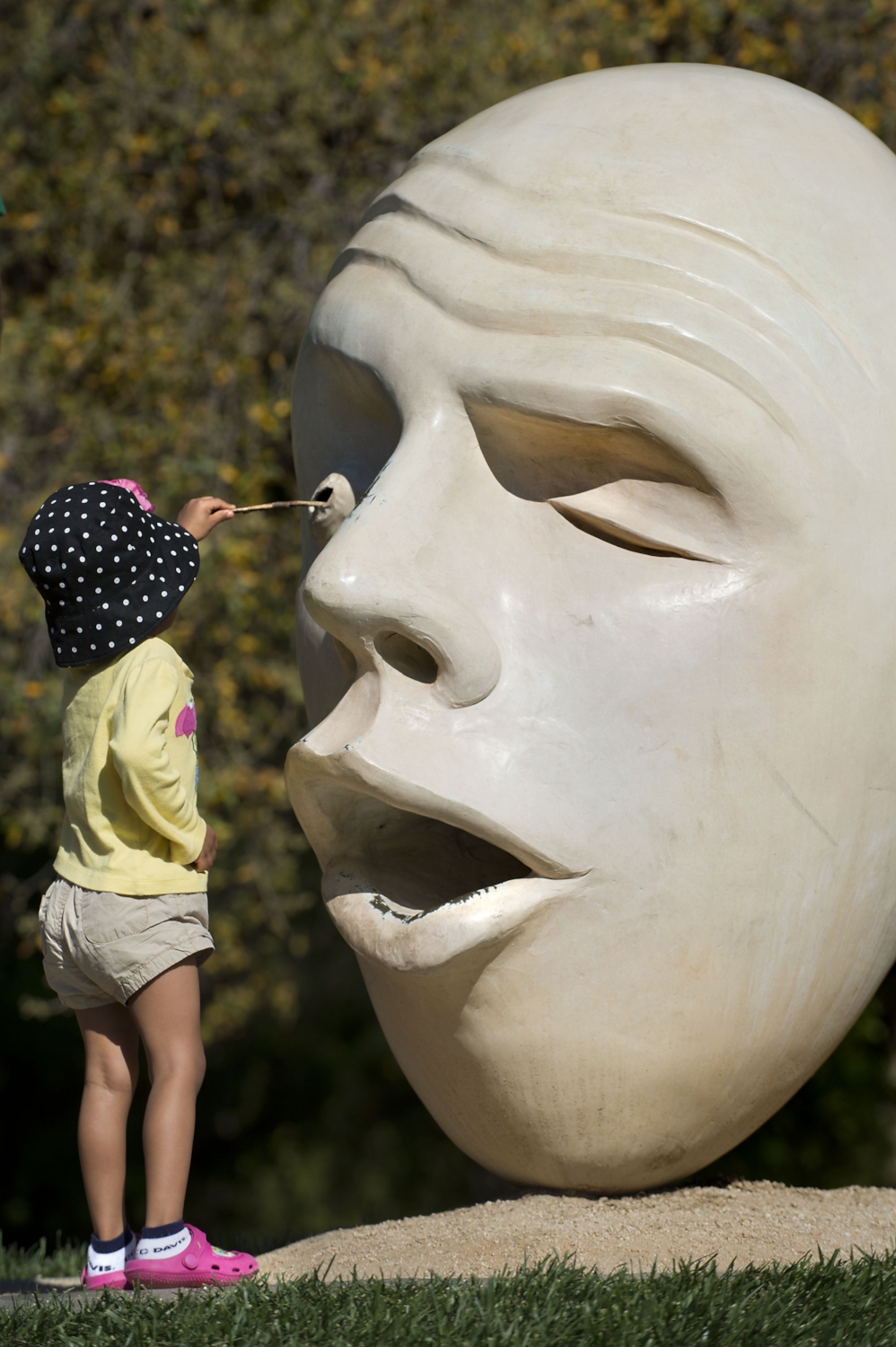  Reese Jackson 3 of Sacramento pokes a twig into the eye of a sculpted "Egg Head" during the 100th annual Picnic Day at UC Davis in Davis on Saturday, April 12, 2014. 