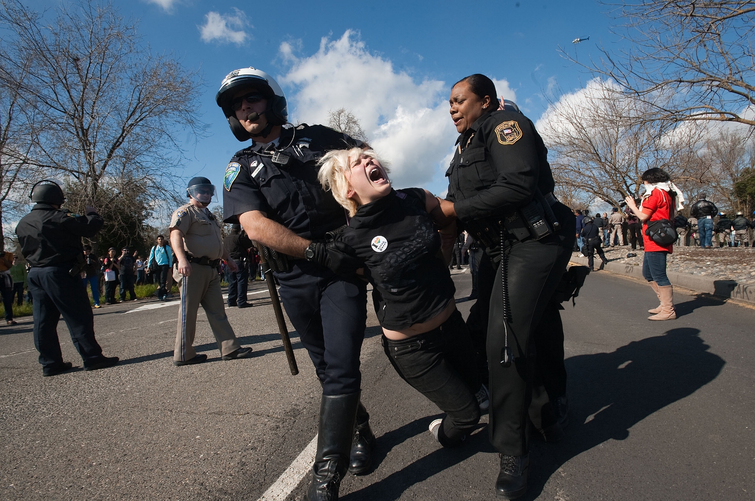 Davis Police and Yolo County Sheriff deputies carry away 5th year UC Davis student Laura Mitchell as students demonstrate at the UC Davis campus on Thursday, March 4, 2010. The students tried to block traffic on Interstate 80