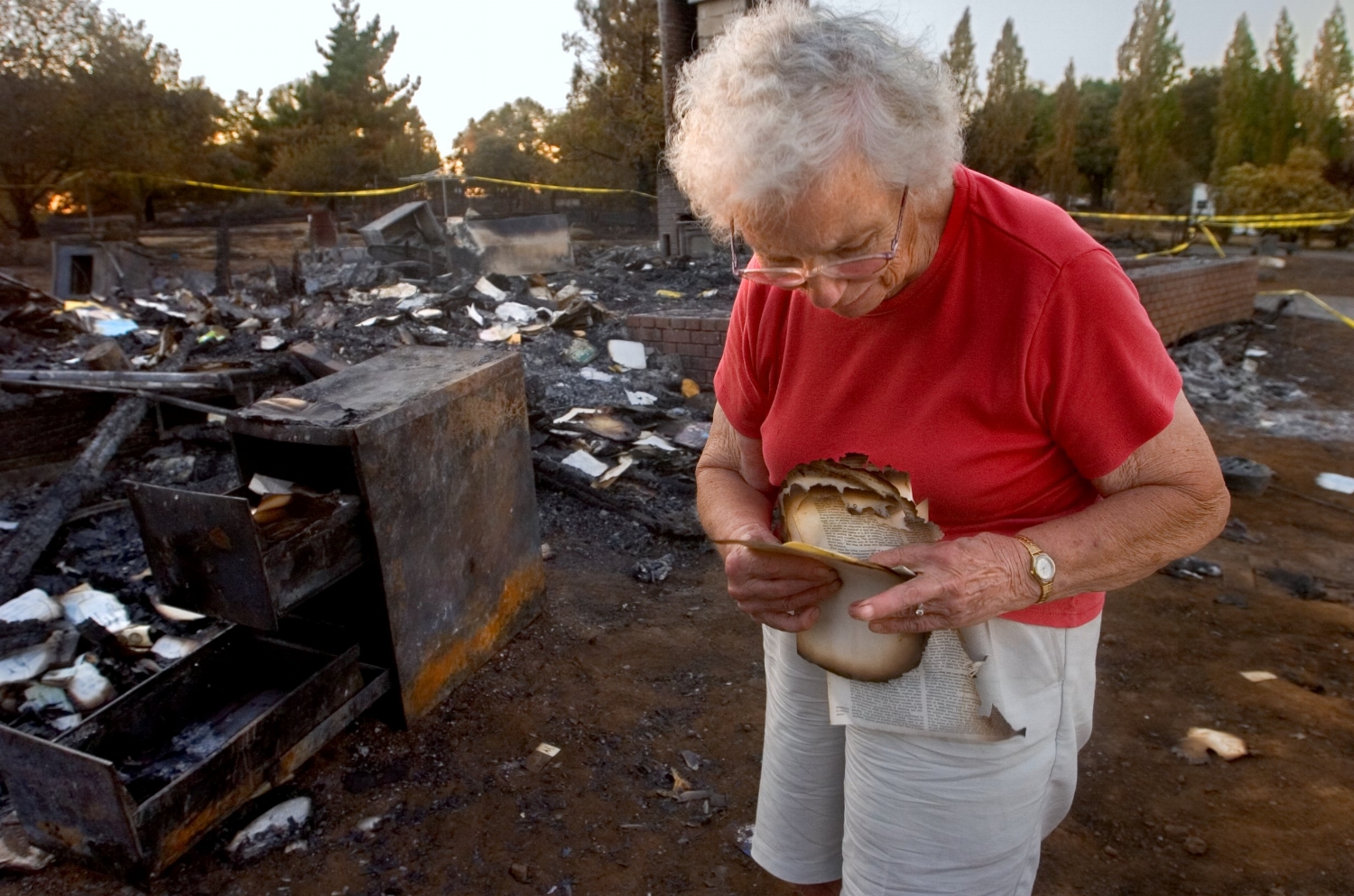 Edith Hoffman picks through the ashes of her home in El Dorado on Wednesday July 19, 2006 after it was destroyed by a wild fire.