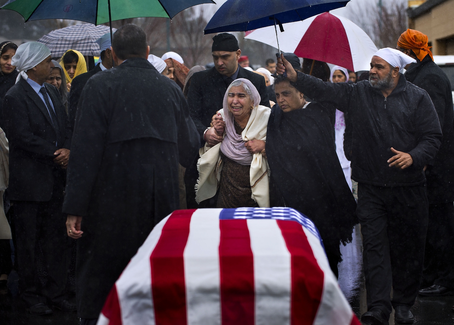  Sukhwinder Kaur, center, is escorted past the flag-draped casket of her son Parminder Singh Shergill at Cherokee Memorial Park in Lodi on Saturday, February 8, 2014. Parminder Singh Shergill was a US Army veteran and was shot to death by police in L