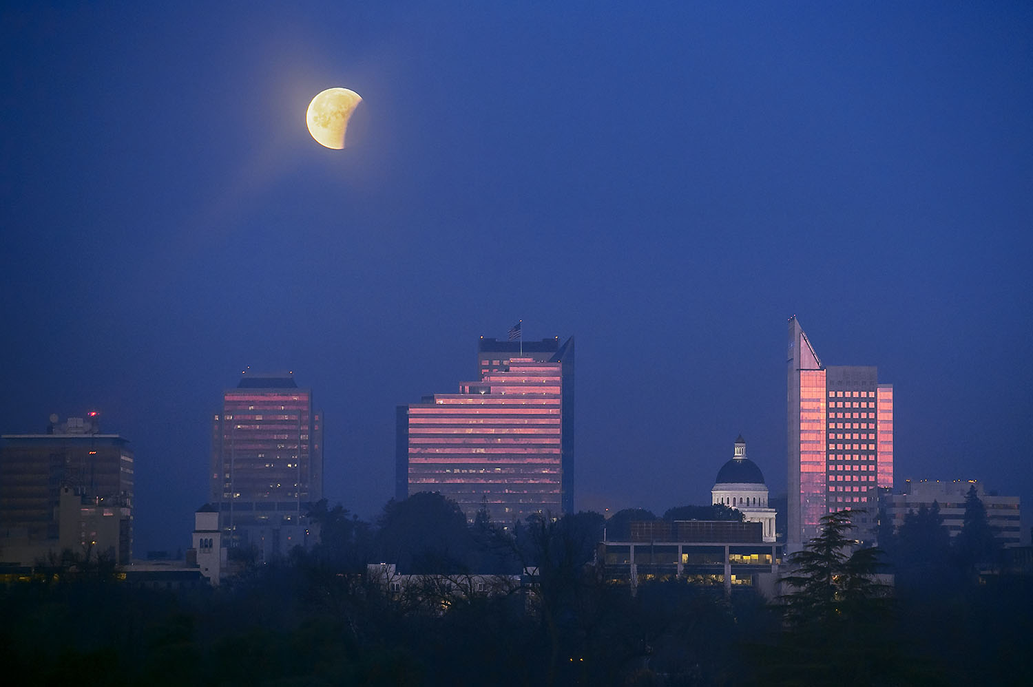 The partially eclipsed moon is seen through a thin veil of morning fog over the skyline of Sacramento on Wednesday, January 31, 2018. This morning's total lunar eclipse coincided with a "blue moon" and a "super moon."