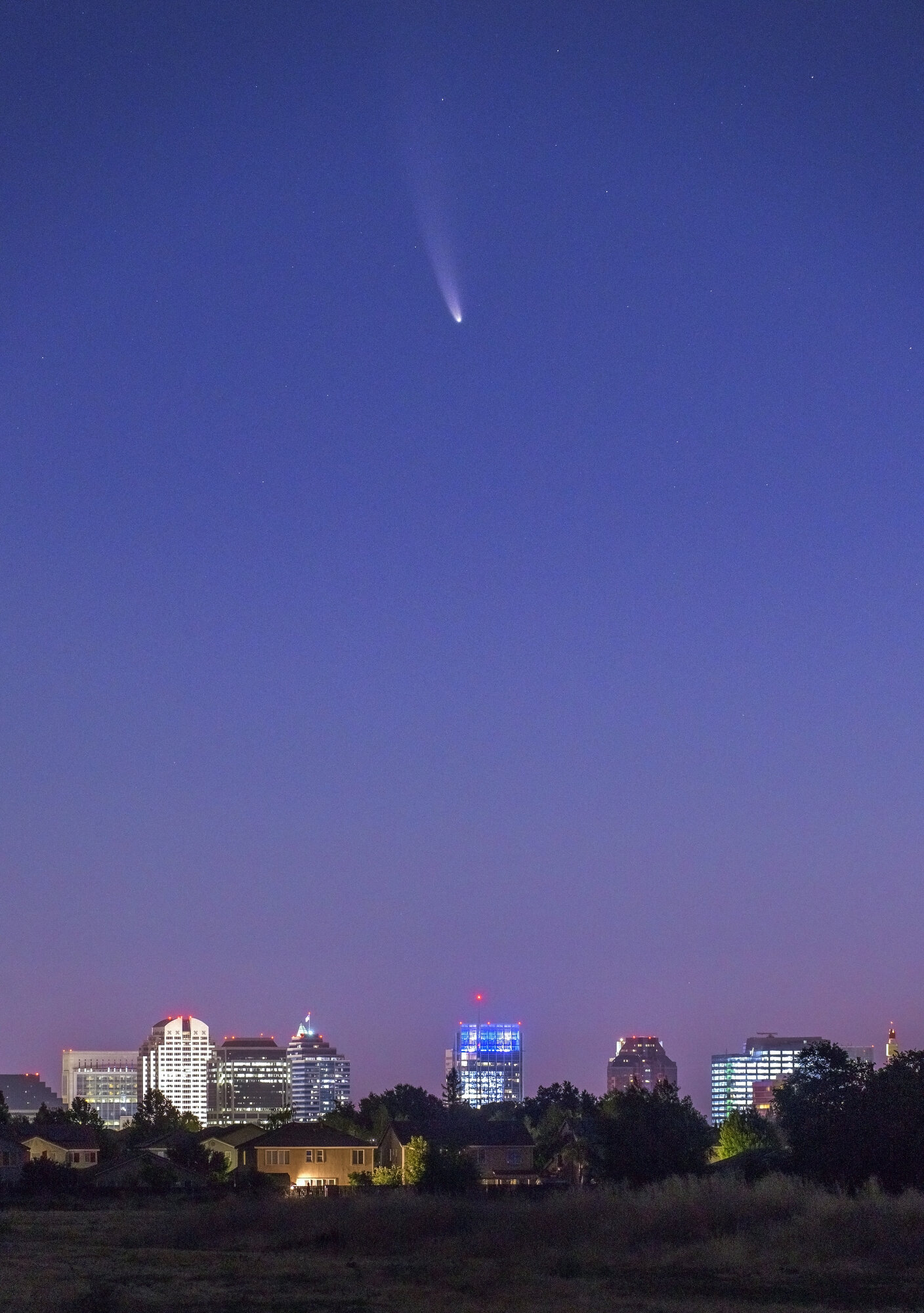  Seen from West Sacramento, comet C/2020 F3, commonly referred to as comet 'Neowise'  is visible in the northeast sky over the skyline of Sacramento, Calif.  Sunday, Jul. 12, 2020. 