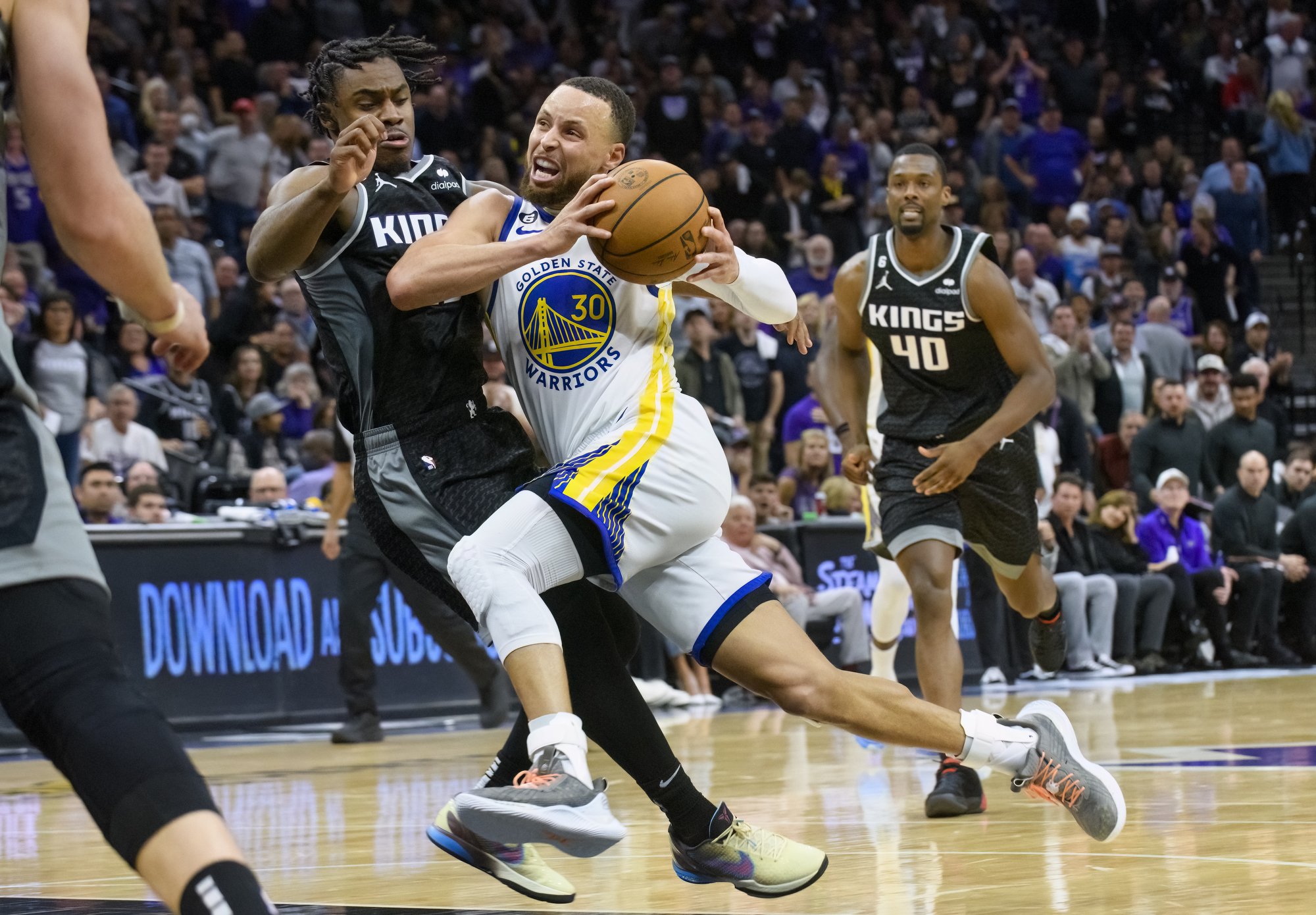  Golden State Warriors guard Stephen Curry (30) drives to the basket past Sacramento Kings guard Davion Mitchell during the second half of Game 2 in the first round of the NBA basketball playoffs in Sacramento, Calif., Monday, April 17, 2023. The Kin