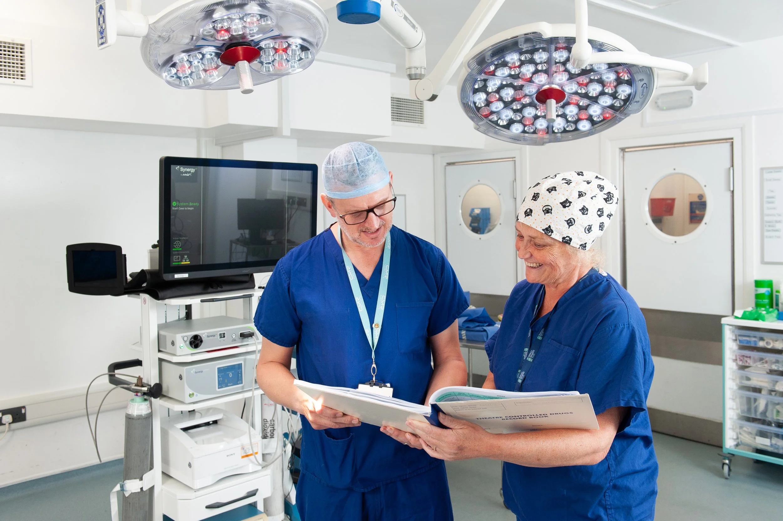 Healthcare PR and commercial photography showing two surgeons working together in a clinical hospital theatre setting.