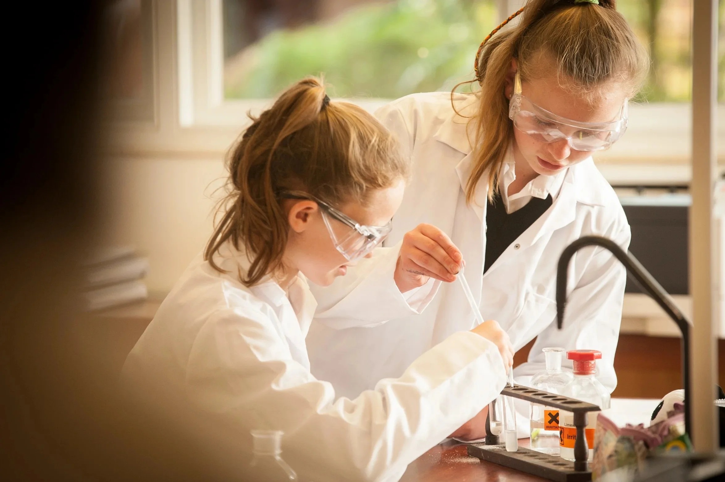 Editorial prep school PR photography showing junior school pupils collaborating on a STEM experiment in a modern, well-equipped science laboratory.