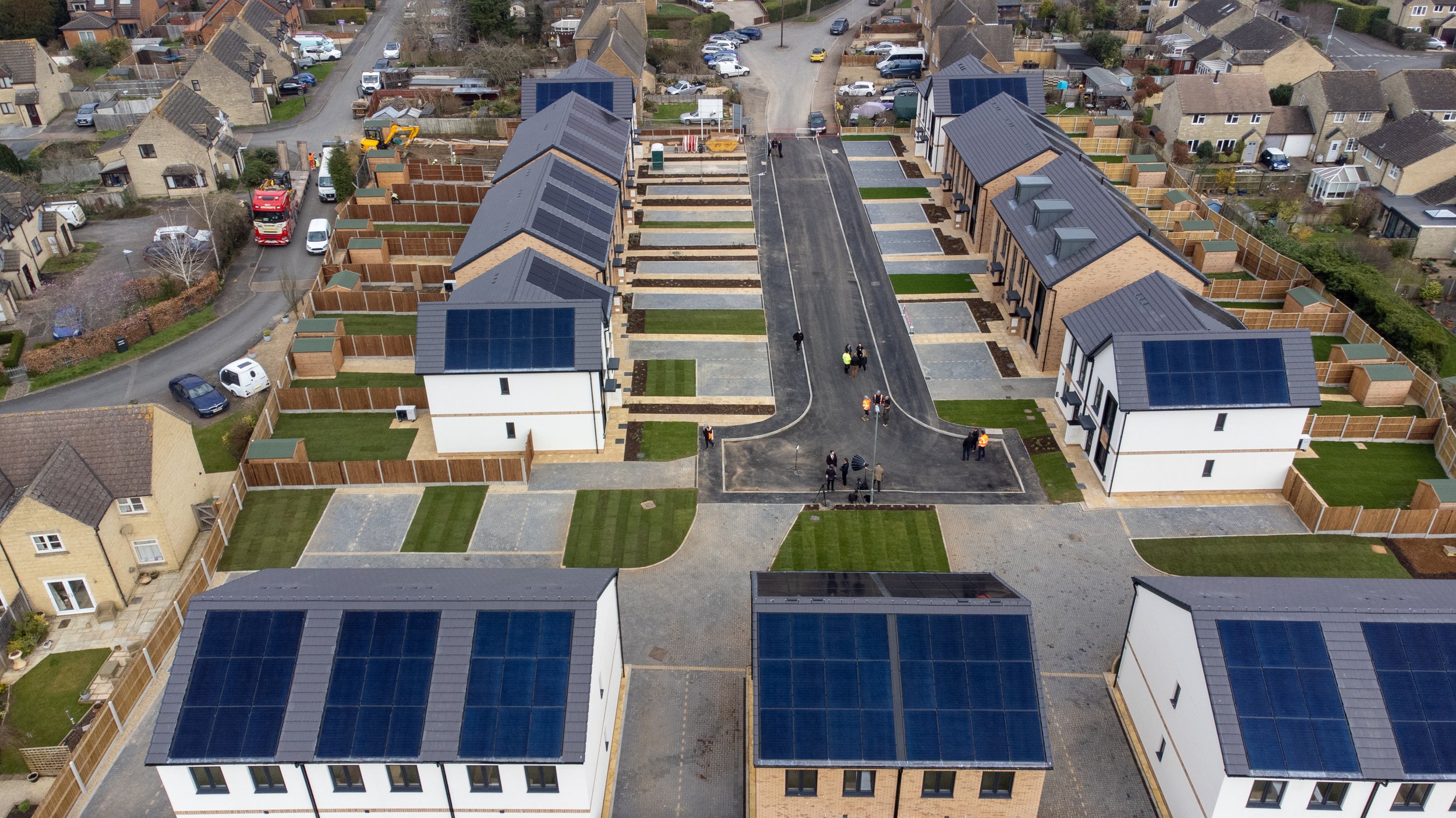 A high-angle aerial photograph of a newly developed residential area, showcasing the modern housing layout.