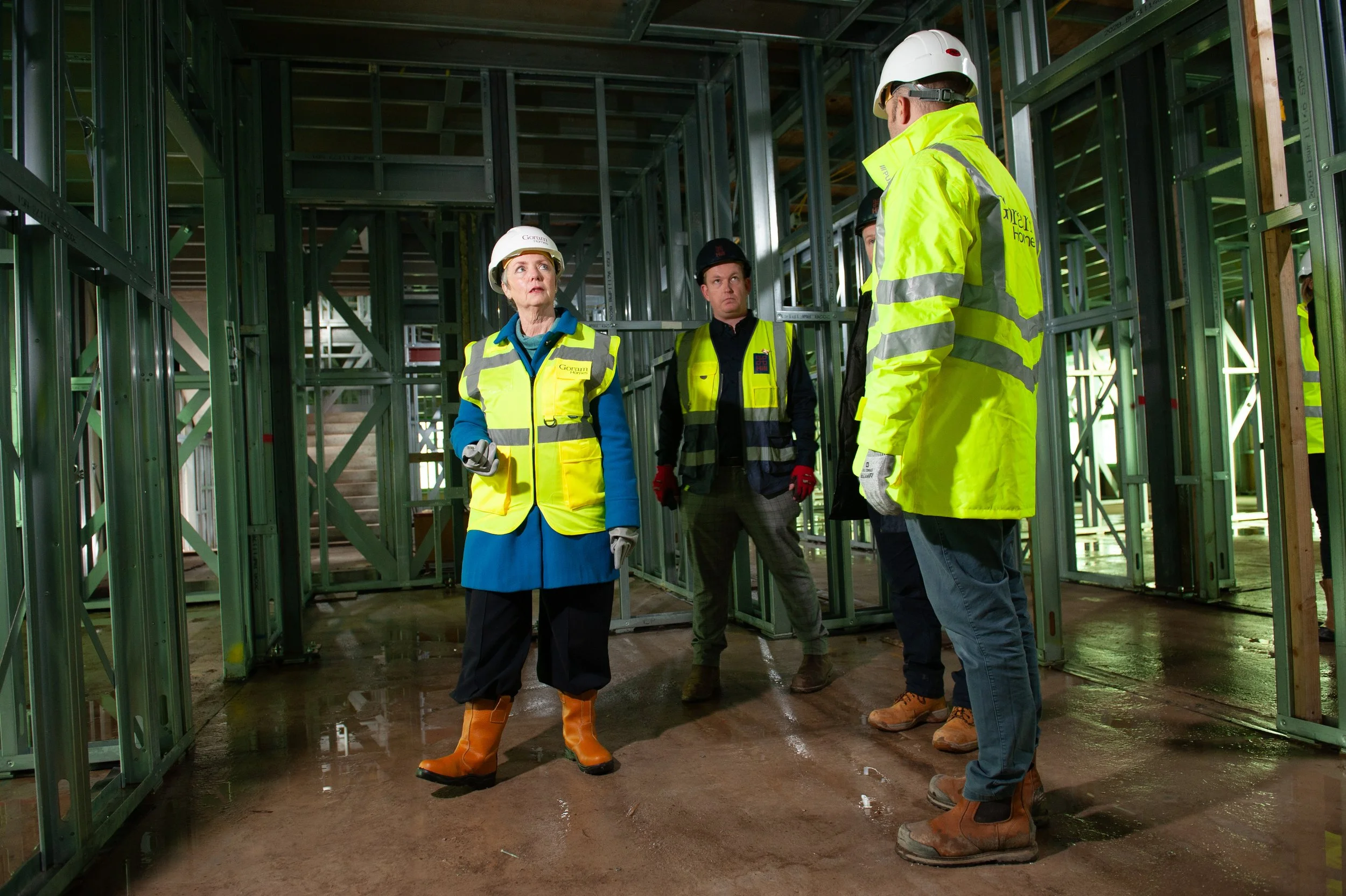 Bristol South MP Karin Smyth touring a Goram Homes construction site wearing high-vis safety gear.