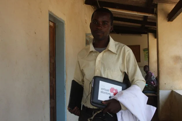 Health officer Kennedy Mulenga at Ngwerere Clinic holding an old Virtual Doctors netbook computer in his left hand and a new Virtual Doctors tablet computer in his right hand. Credit: James Jeffrey/IPS