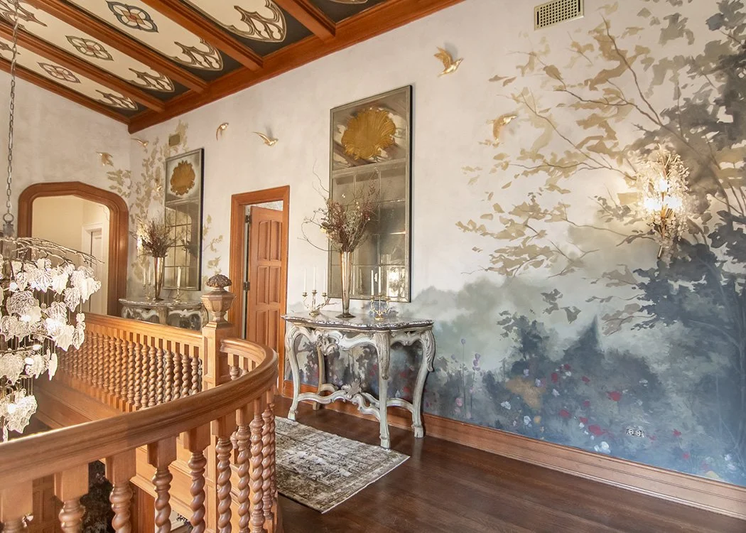 Whimsical landscape mural in Tudor mansion stairwell