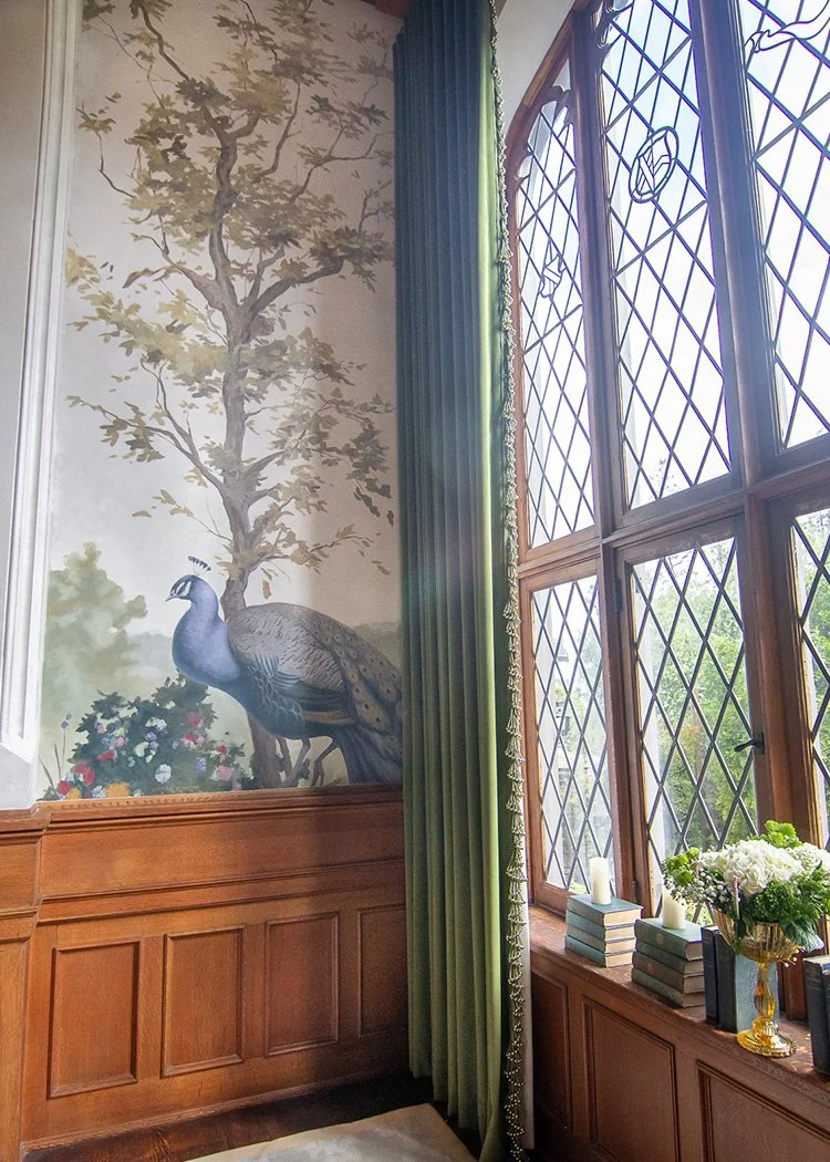 Whimsical nature mural with tree, leaves and peacock.