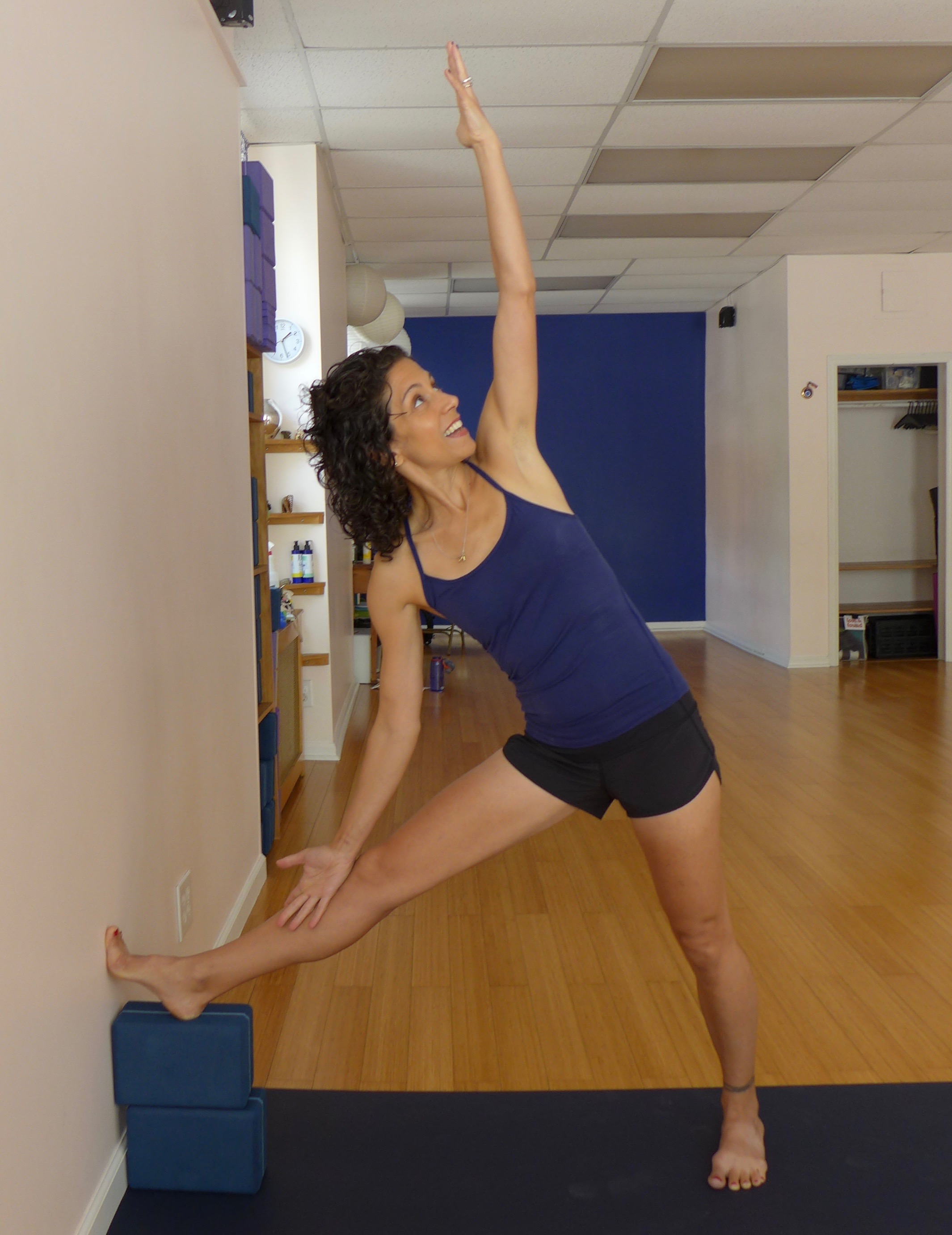 Triangle variation with wall and blocks, Part 2: If you feel stable in the version above, then try placing your hand on your thigh or shin. 