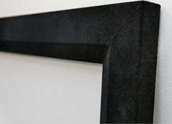 Close-up of a black picture frame corner against a white wall.