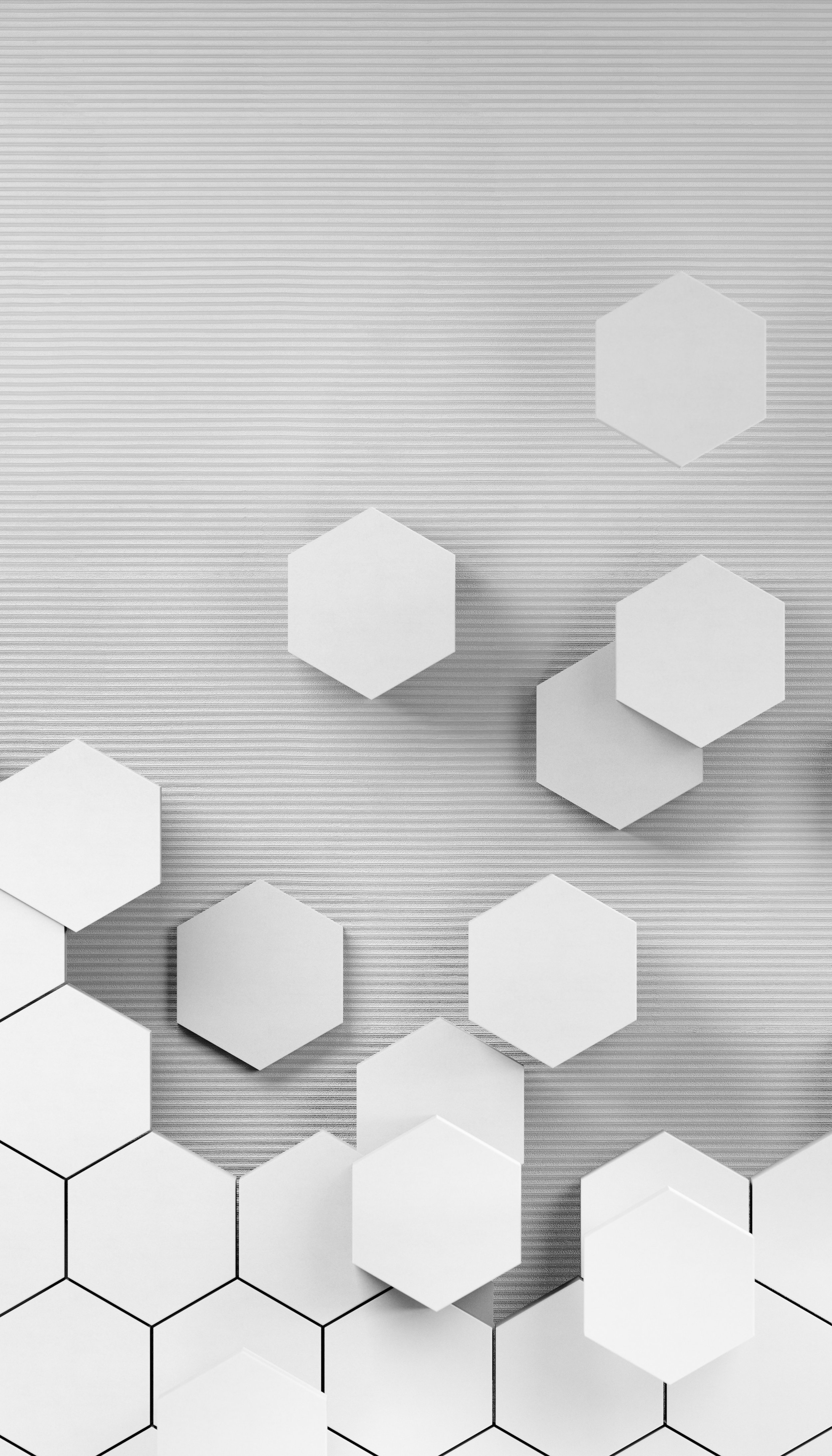 Several white hexagonal and pentagonal paper cutouts on a textured, striped grey background. Some hexagons are outlined in black, with a few overlapping.