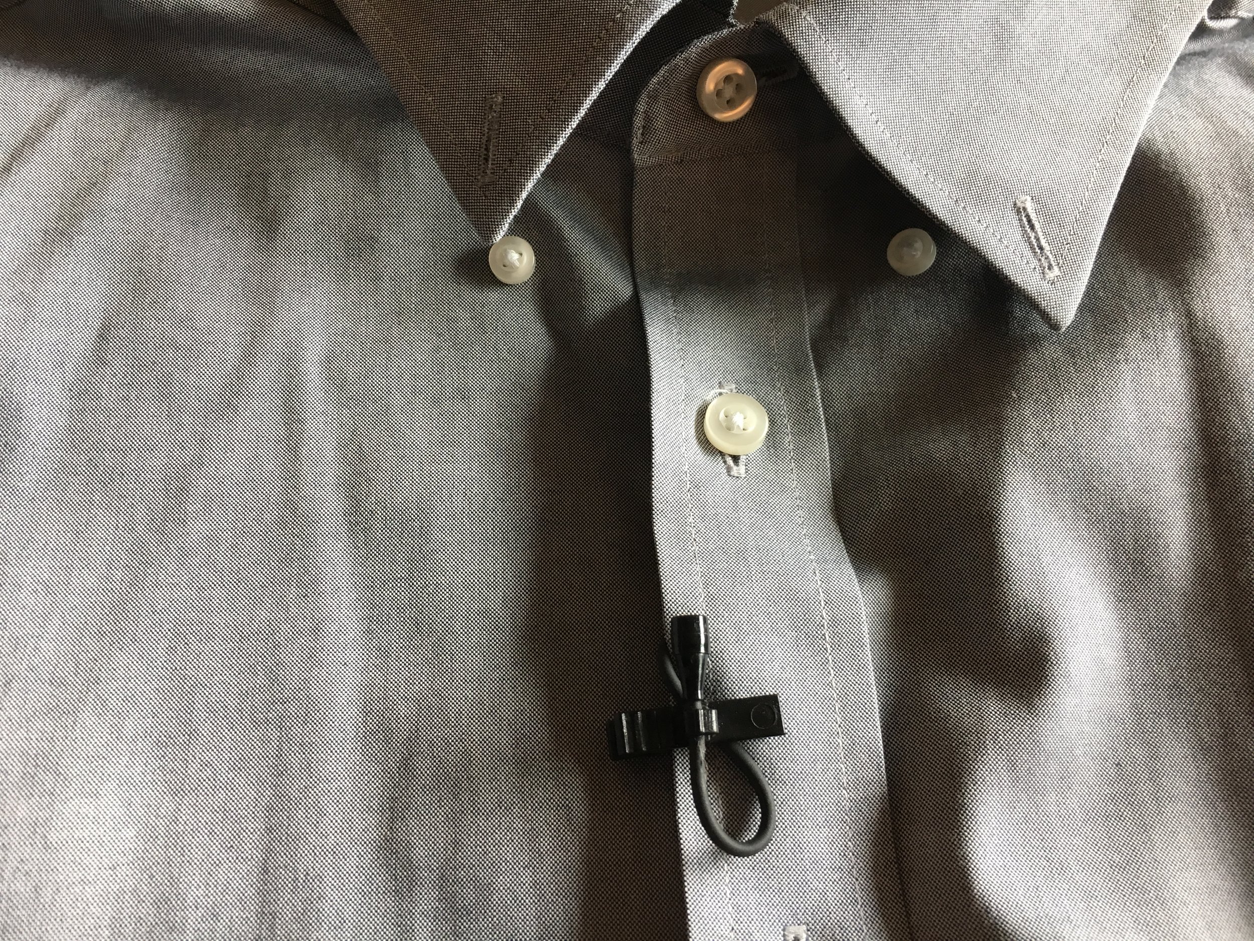 If you are miking a button up, clip the mic with the cord sandwiched under the clip with the mic facing up towards the mouth. 