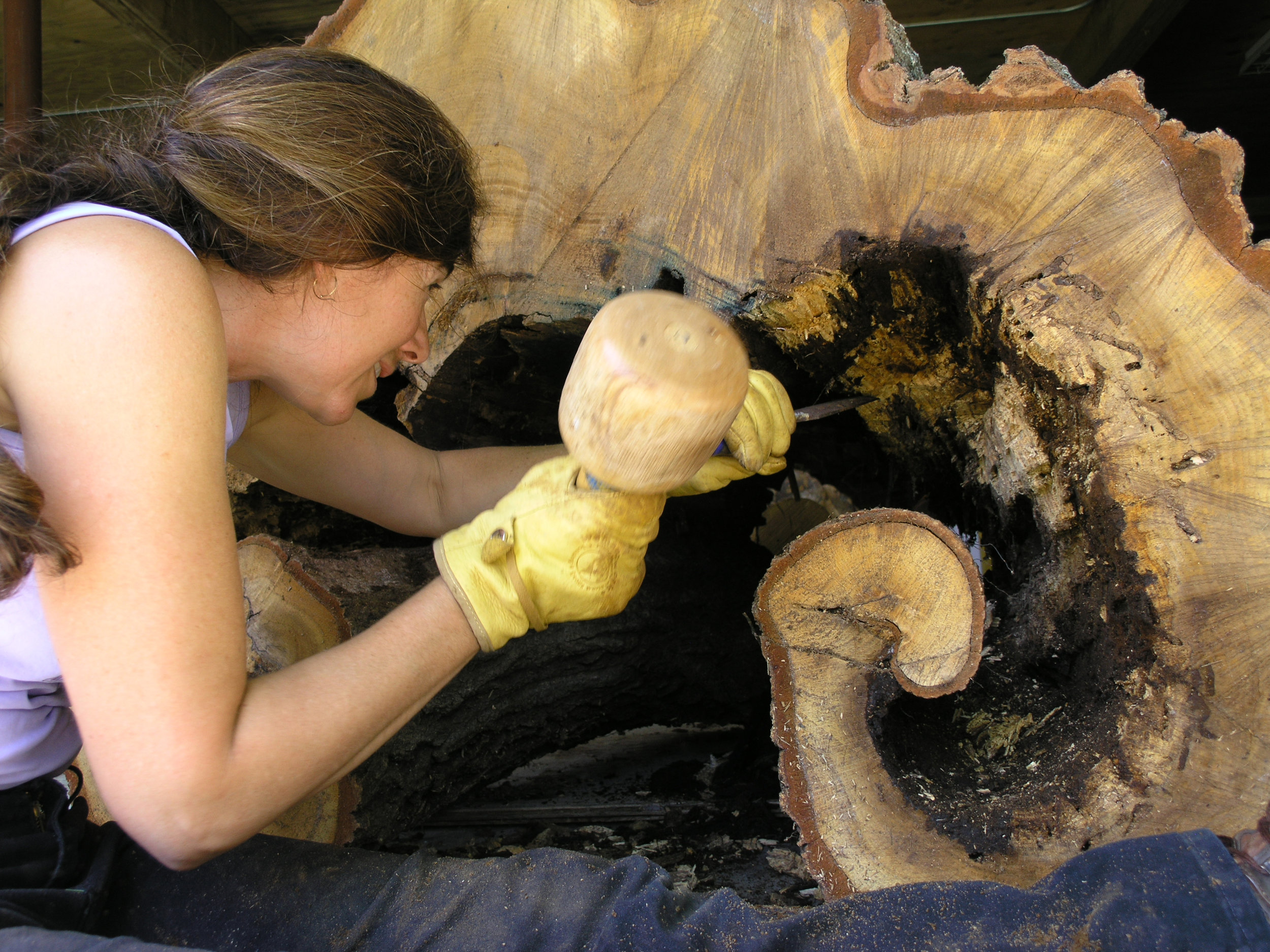 Carving the wood to create a smooth interior.