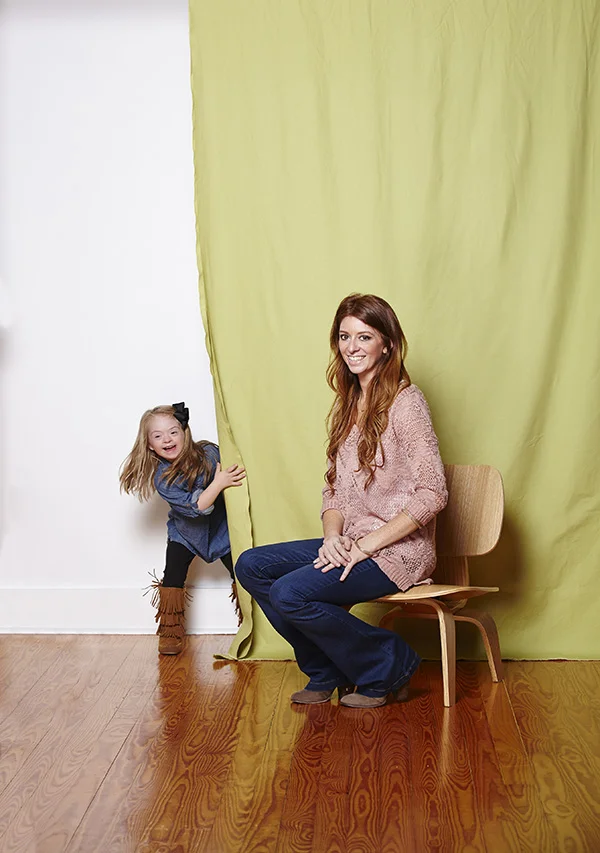 Khloe plays peek-a-boo with mom Kristen at the shoot. Photo by Lily Darragh .