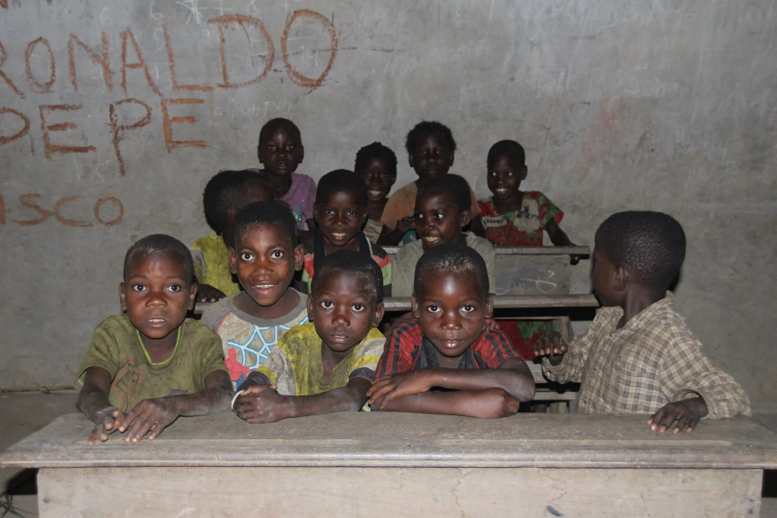 Barn av bantuer og urfolket ved skolebenken. Urbefolkningen er de vi tidligere kjenner som pygméer. Det er nå vedtatt en lov i Kongo som har som hensikt å ta vare på urbefolkningens rettigheter. Den sier at det ikke er lov å bruke ordet pygmé og dette vil vi respektere.