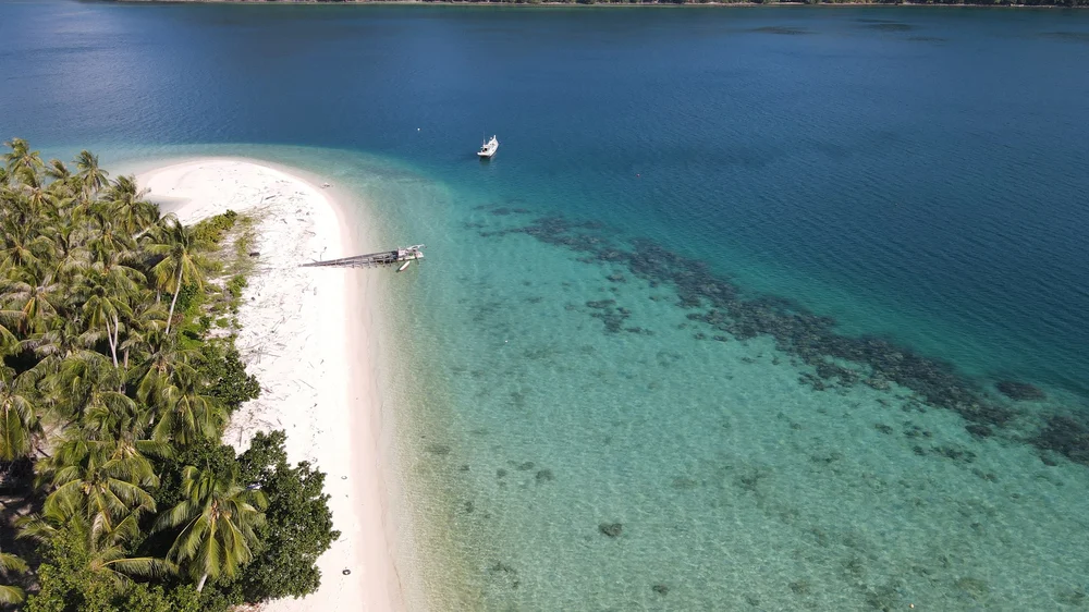 Aerial view of turquoise water and white-sand coastline in the Karimata Islands