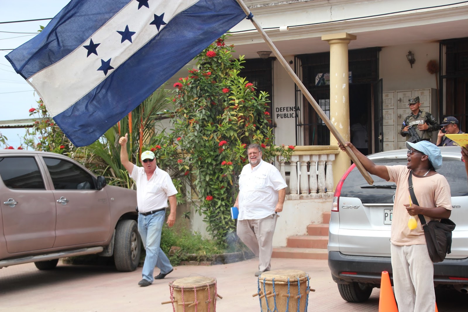 Photo caption: Randy Jorgensen (left) waving obnoxiously to the Garifuna community waiting outside the courthouse to hear the results. Hernan Batres (middle), the General Manager of the cruise ship terminal constructed by Jorgensen's second company in Trujillo, Banana Coast, accompanied Jorgensen to the hearing.