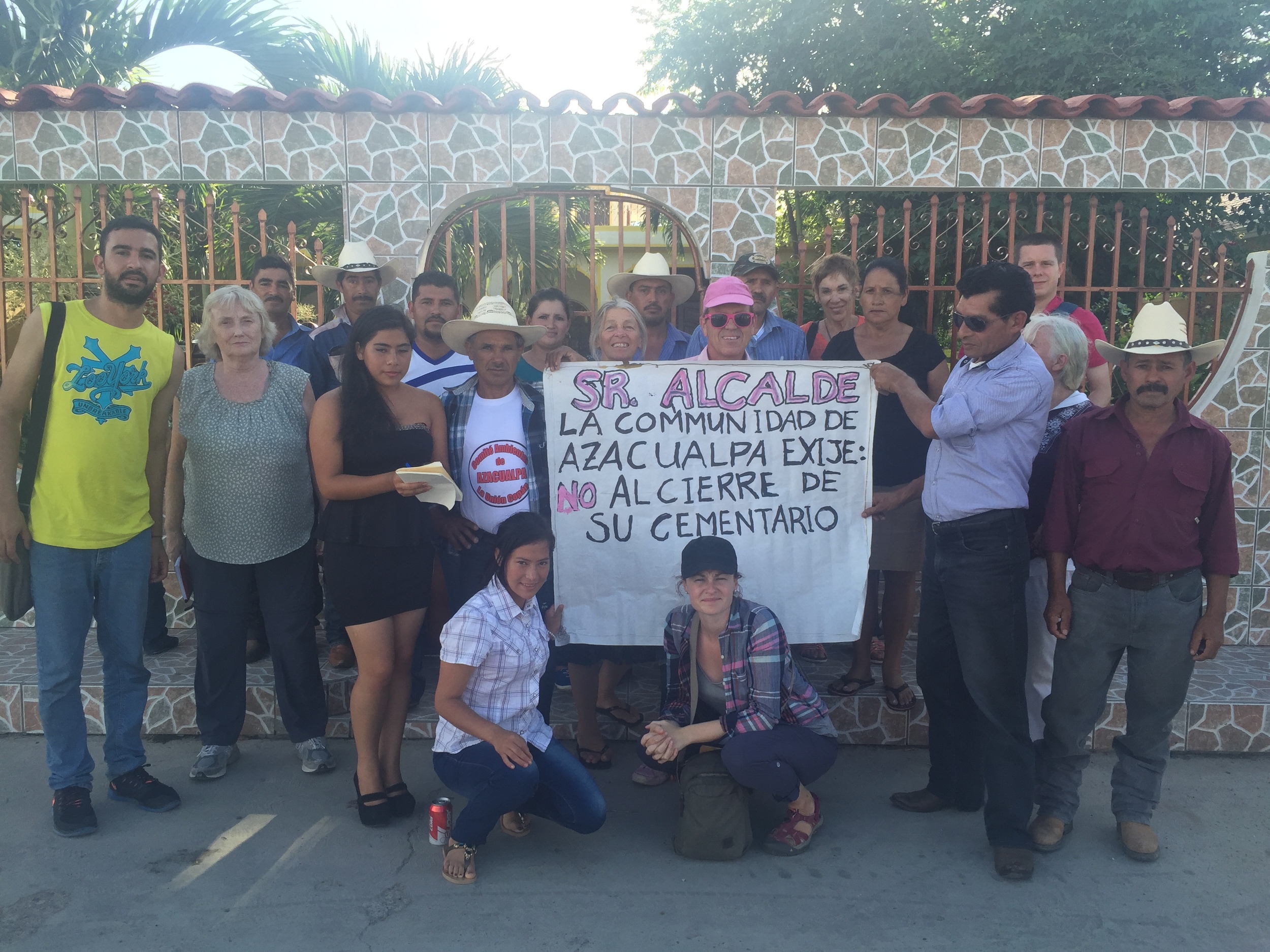 In front of the house of the mayor of La Unión, Copan with community members and environmentalists from the community of Azacualpa that are fighting to protect their 200-year old cemetery under threat by the expansion of Canadian mining company, Aura Minerals. Sign reads: "Mr. Mayor. The community of Azacualpa demands: no to the closure of their cemetery."