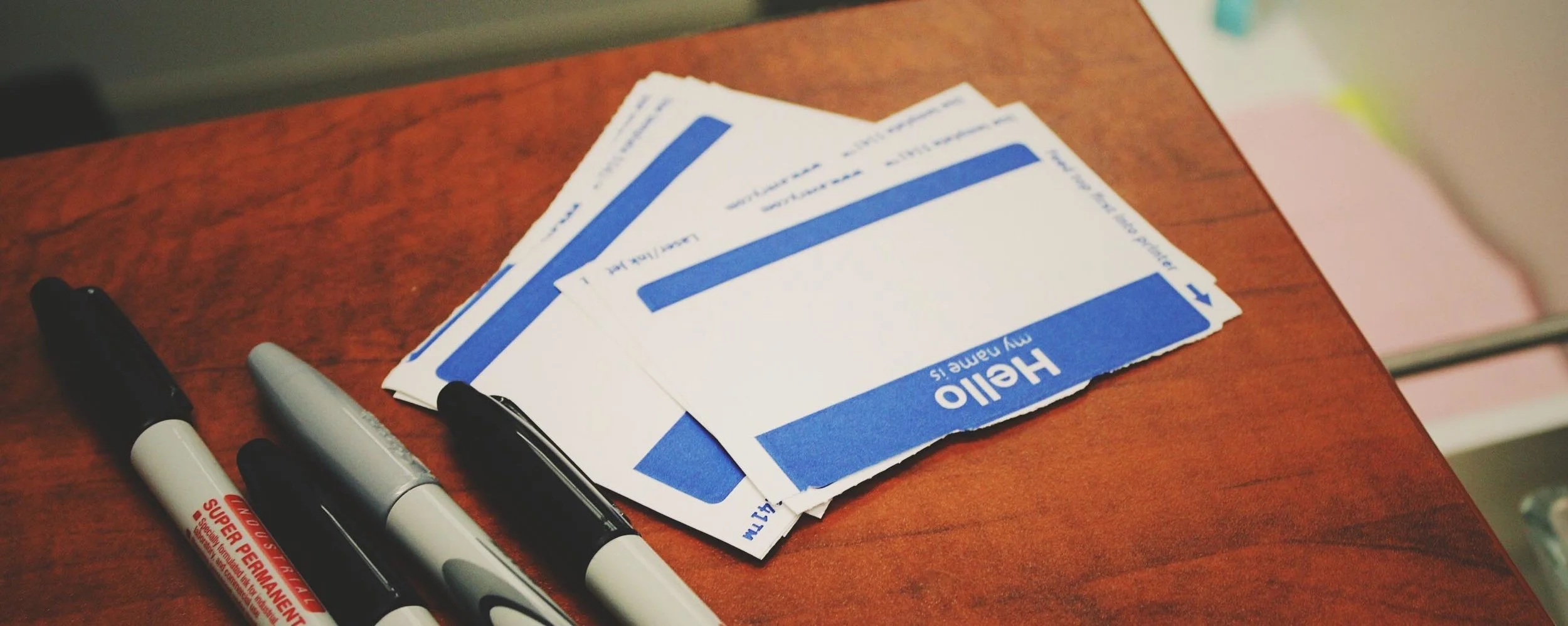  Image of name tags and pens on a table. 
