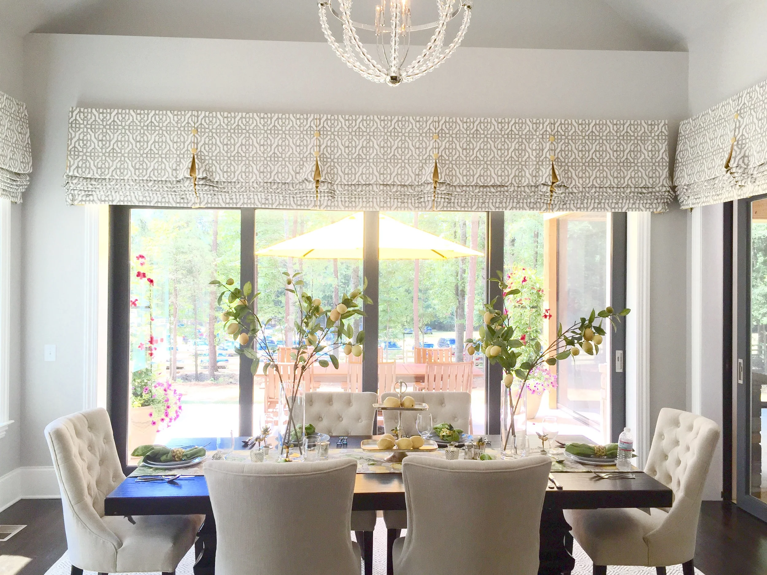 This grand breakfast room had an inviting 6 person table and magnificent views with windows on all three walls. Tall table accessories brought the eye up to a beautiful chandelier.