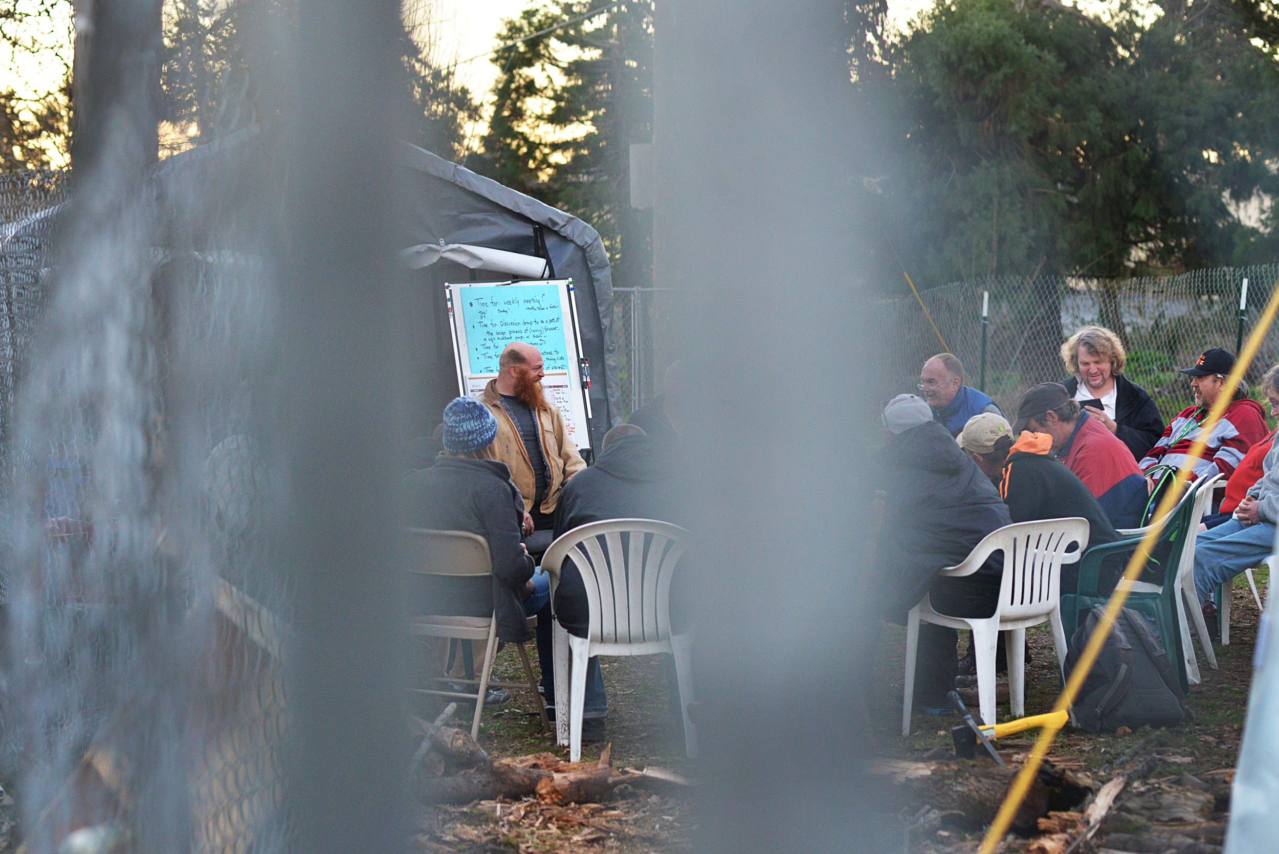 Eugene, Ore. - Nathan “Red” Showers, 40, leads the Nightingale Health Sanctuary Tuesday Night meeting to review rules of the community, such as no drinking or smoking on grounds. By: Debra Josephson