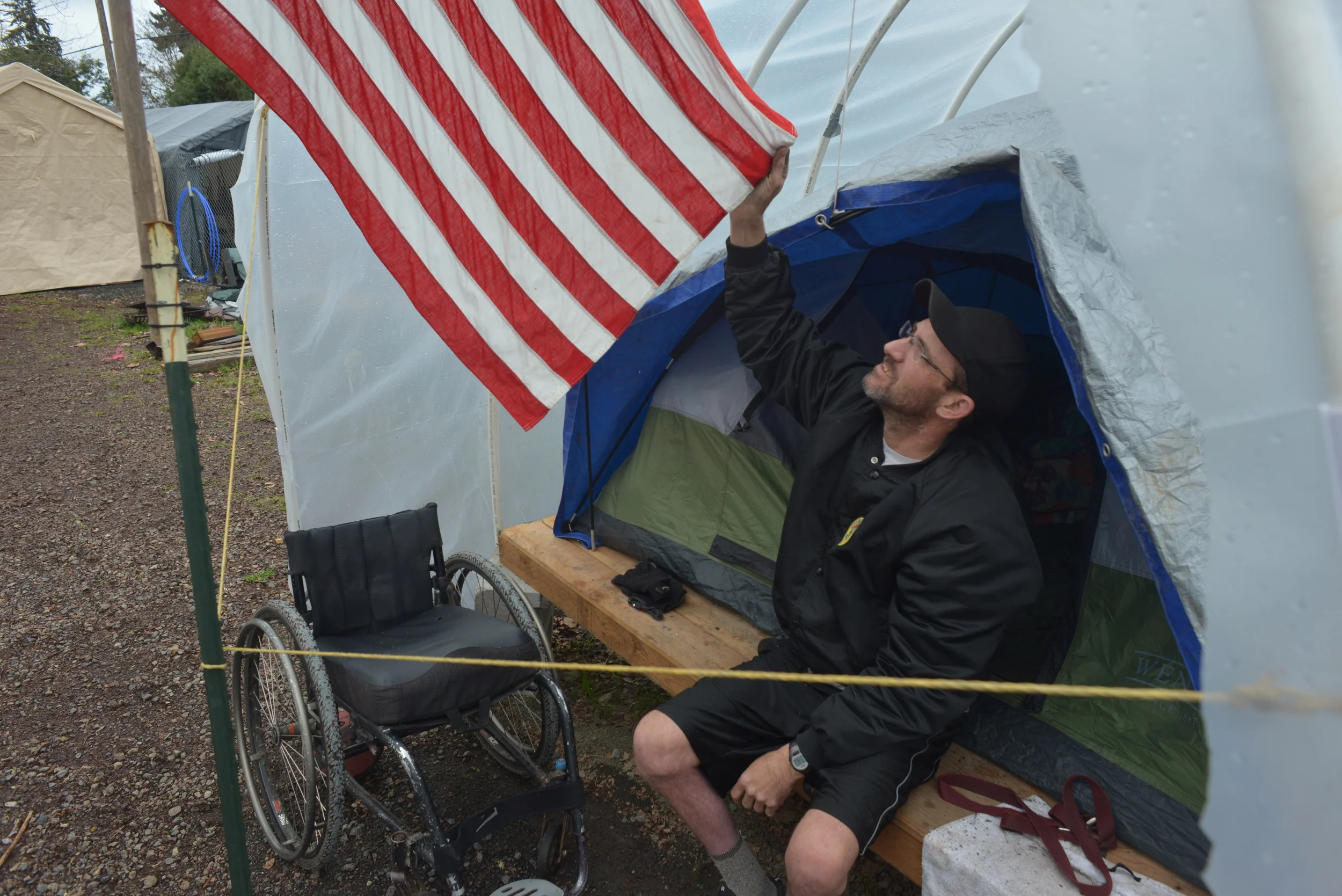  Eugene, ORE - “Medicine Man” Eric holds the American flag at his conestega housing. He says he is grateful for the opportunity to live at Nightingale Health Sanctuary. Photo by: Debra Josephson 