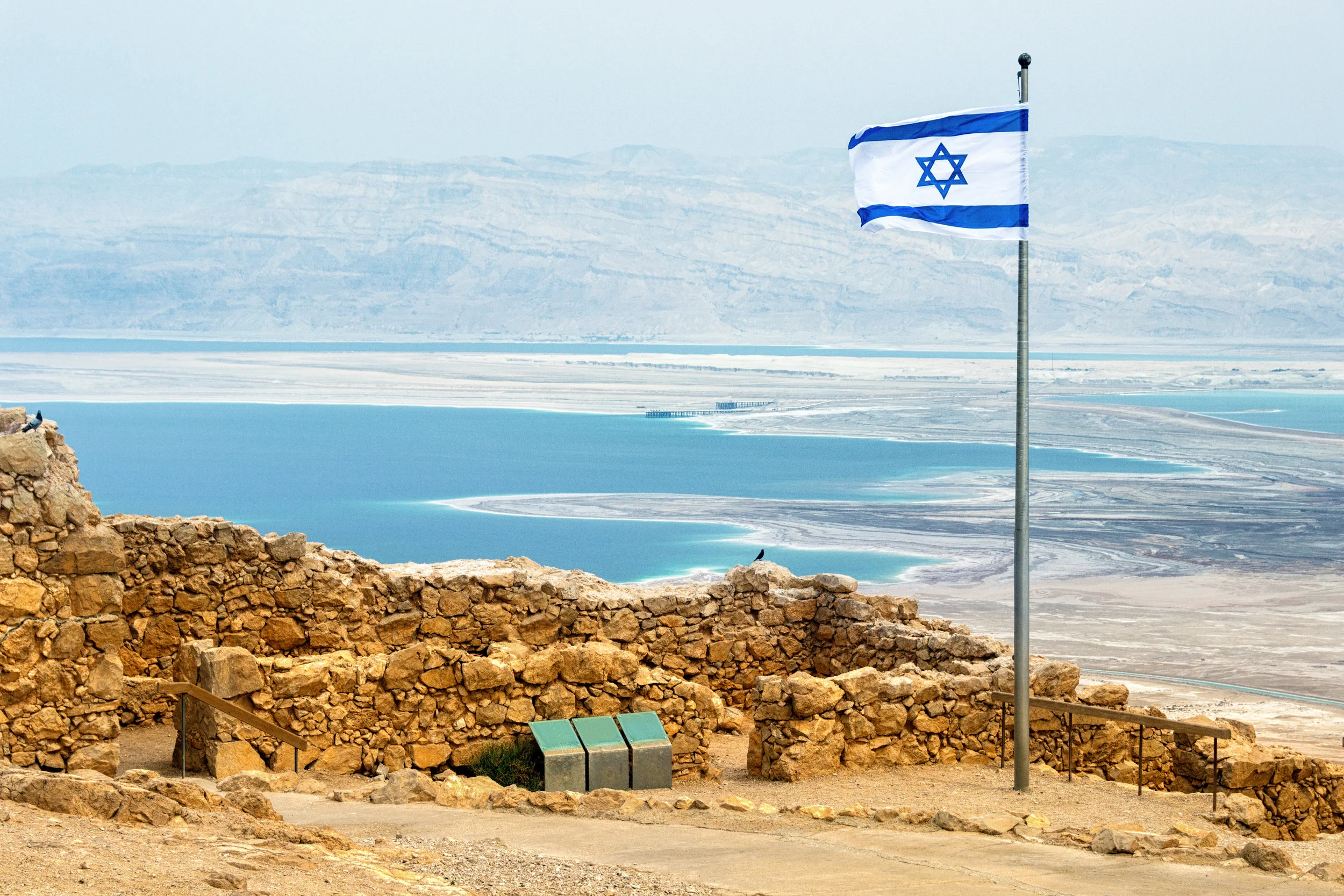 Israeli-flag-with-the-ruins-on-Masada-with-the-Dead-Sea-on-the-background-889843646_5113x3409.jpeg