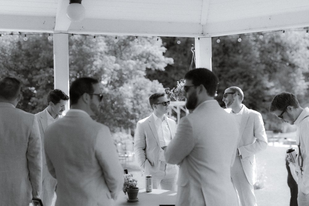 015_cameron-alexa-wedding-74_groomsmen mingling on porch.jpg