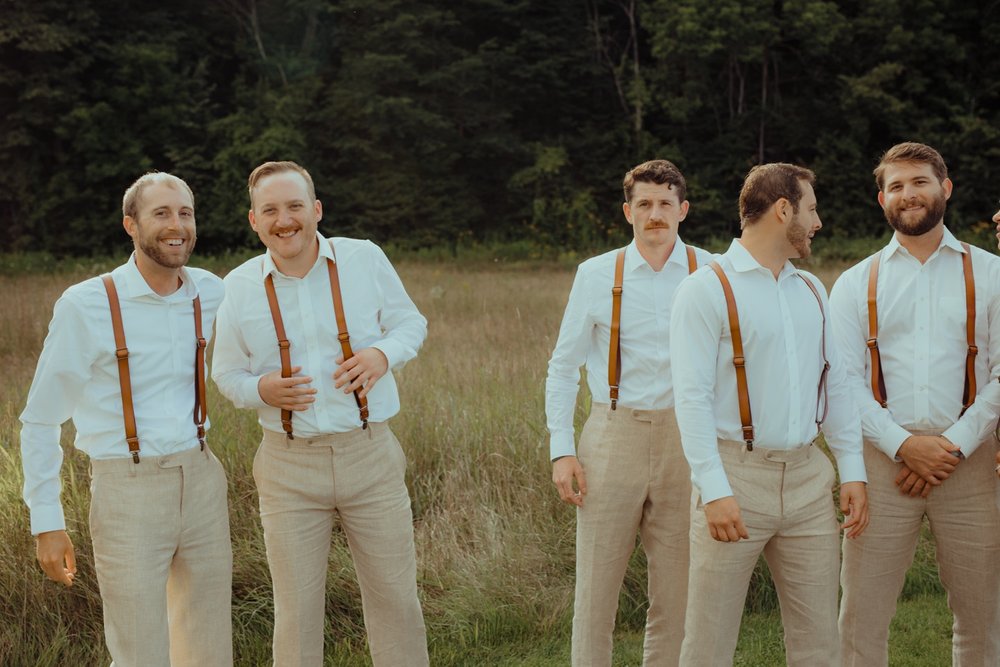 064_cameron-alexa-wedding-424_candid groomsmen suspenders.jpg