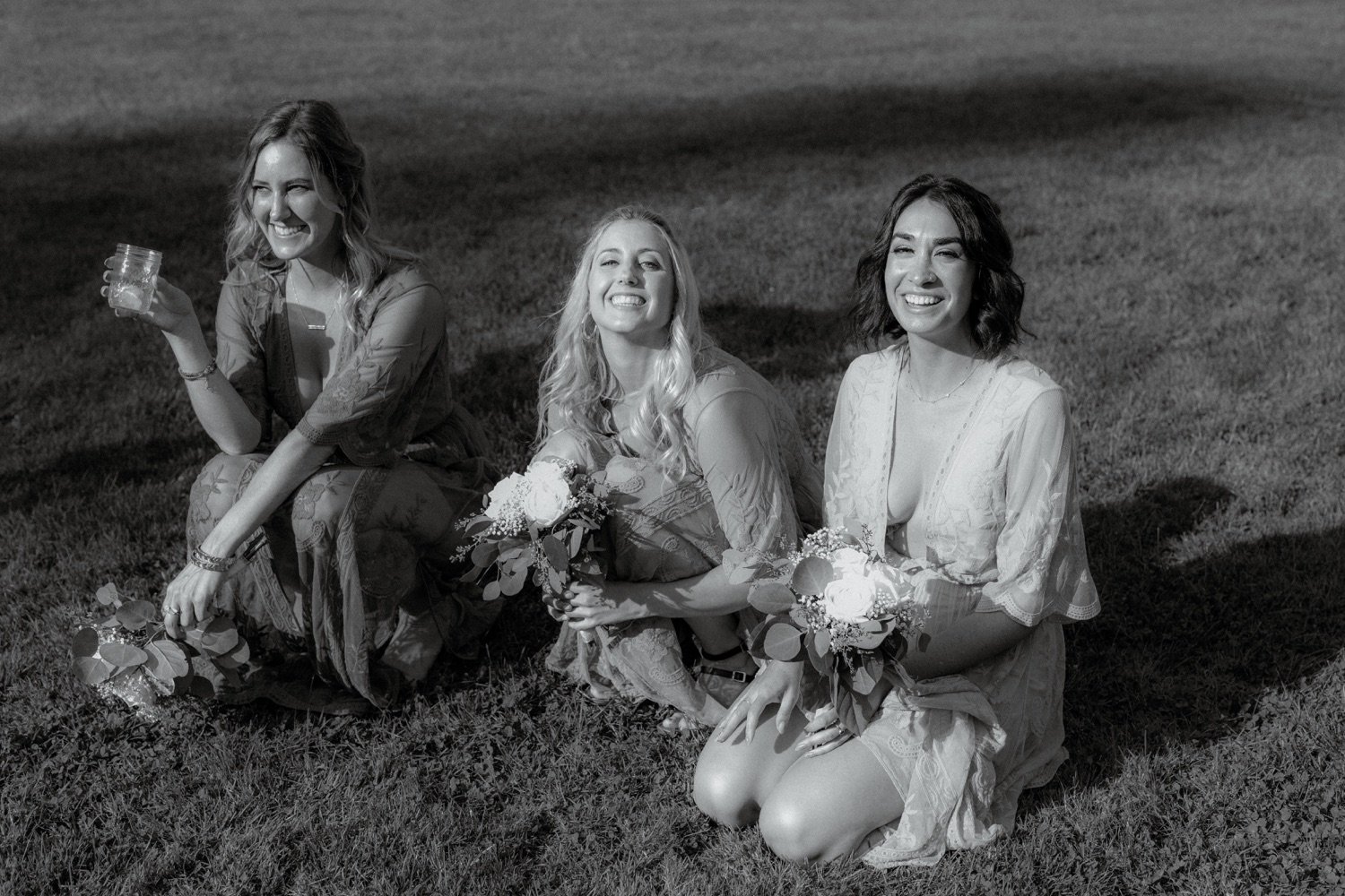066_cameron-alexa-wedding-415_bridesmaids sitting in grass candid .jpg
