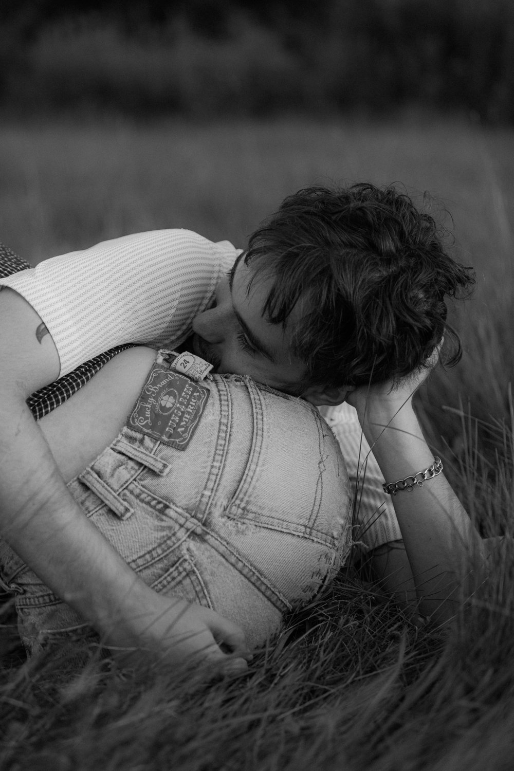 06_young couple cuddling in the grass vintage lucky brand jeans .jpg