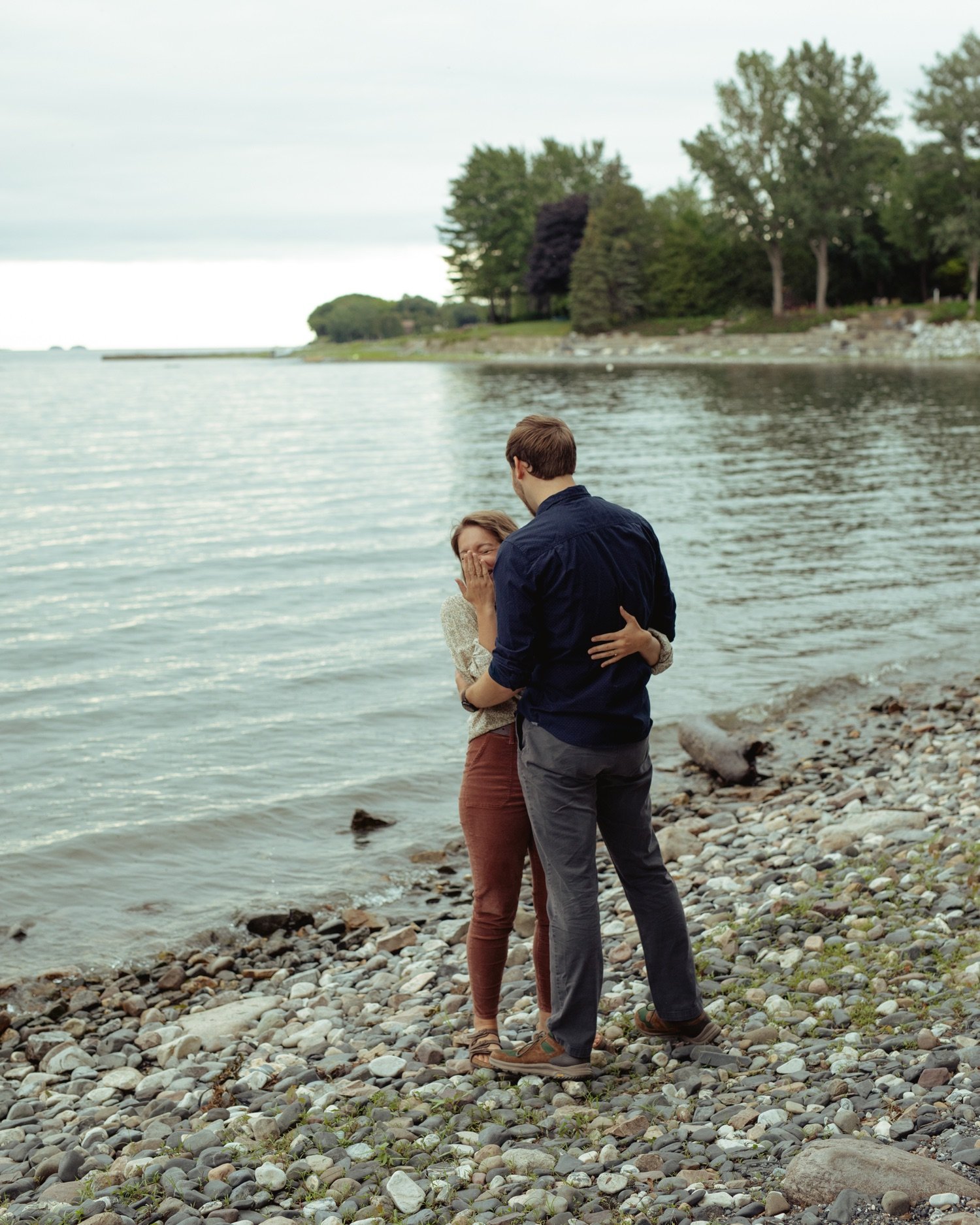 29_young couple laughing and hugging along the lake champlain waterfront in burlington vermont .jpg