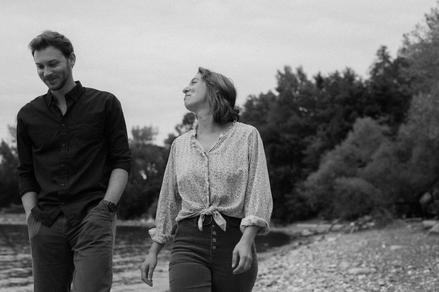 35_smiling couple walking alongside lake champlain for engagement photos in burlington vermont .jpg