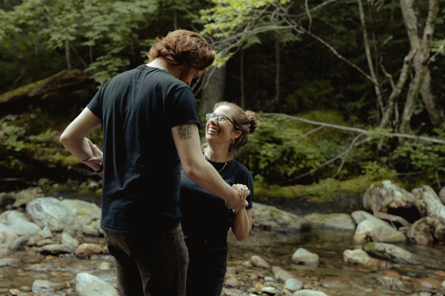 39_couple holding onto each other lovingly as they walk alongside rocky riverbed in hancock vermont .jpg