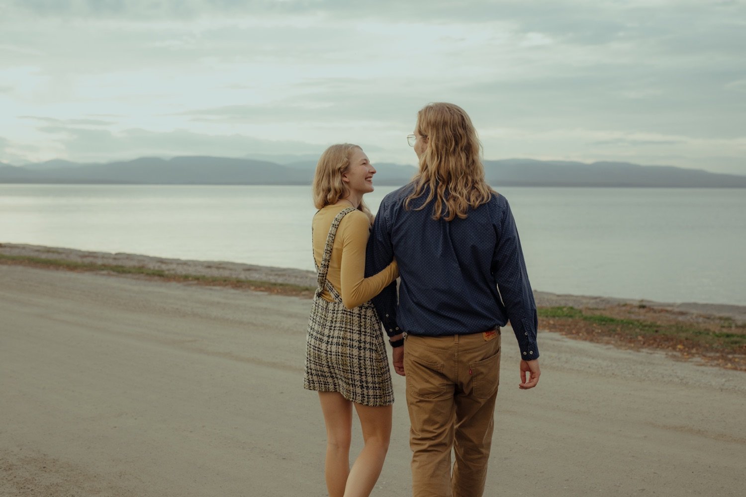 40_couple linking arms walking down the road to the lake champlain waterfront at shelburne farms vermont .jpg