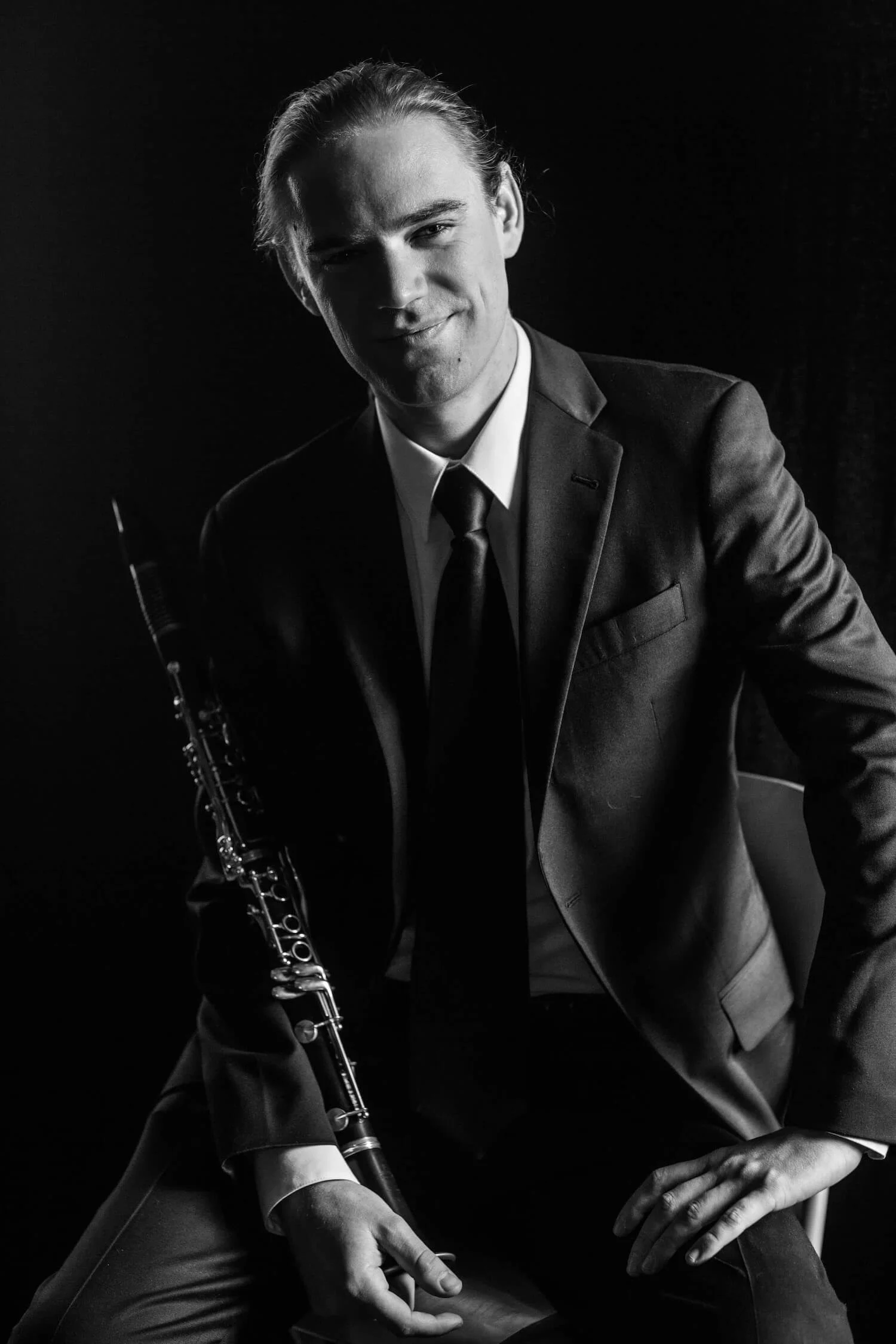 Portrait of Adam Price holding a clarinet, an experienced online clarinet teacher offering clarinet lessons for adults and clarinet lessons for beginners.