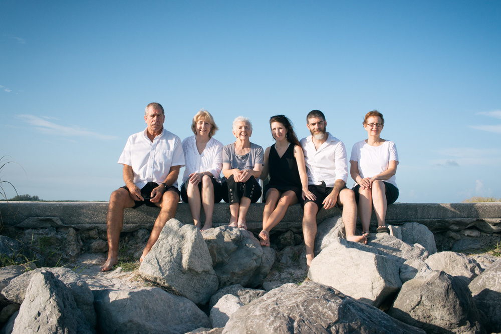 A family beach photo seated atop the rocks at Pass-a-Grille Beach.