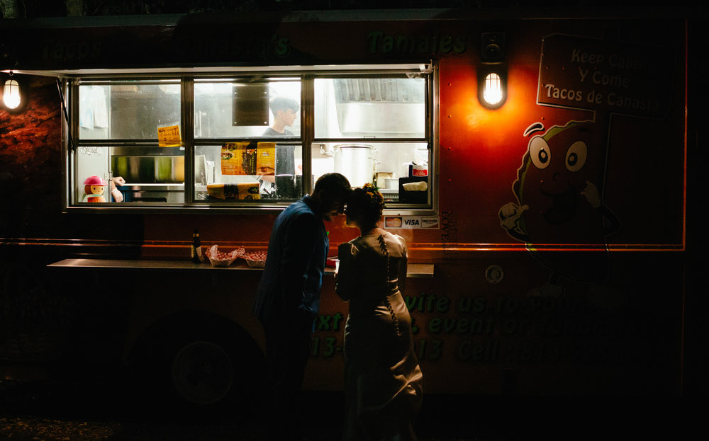 Bride and groom share a quiet moment by the taco truck.