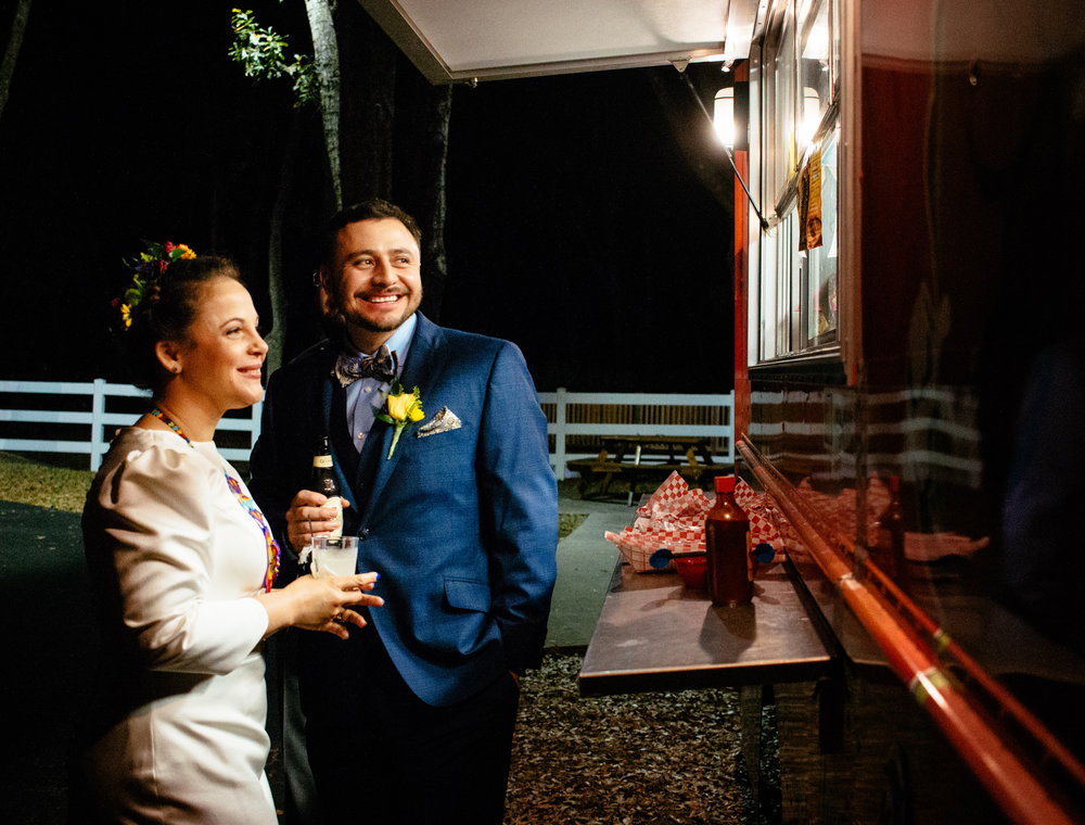 Bride and groom share a sweet moment by the taco truck.