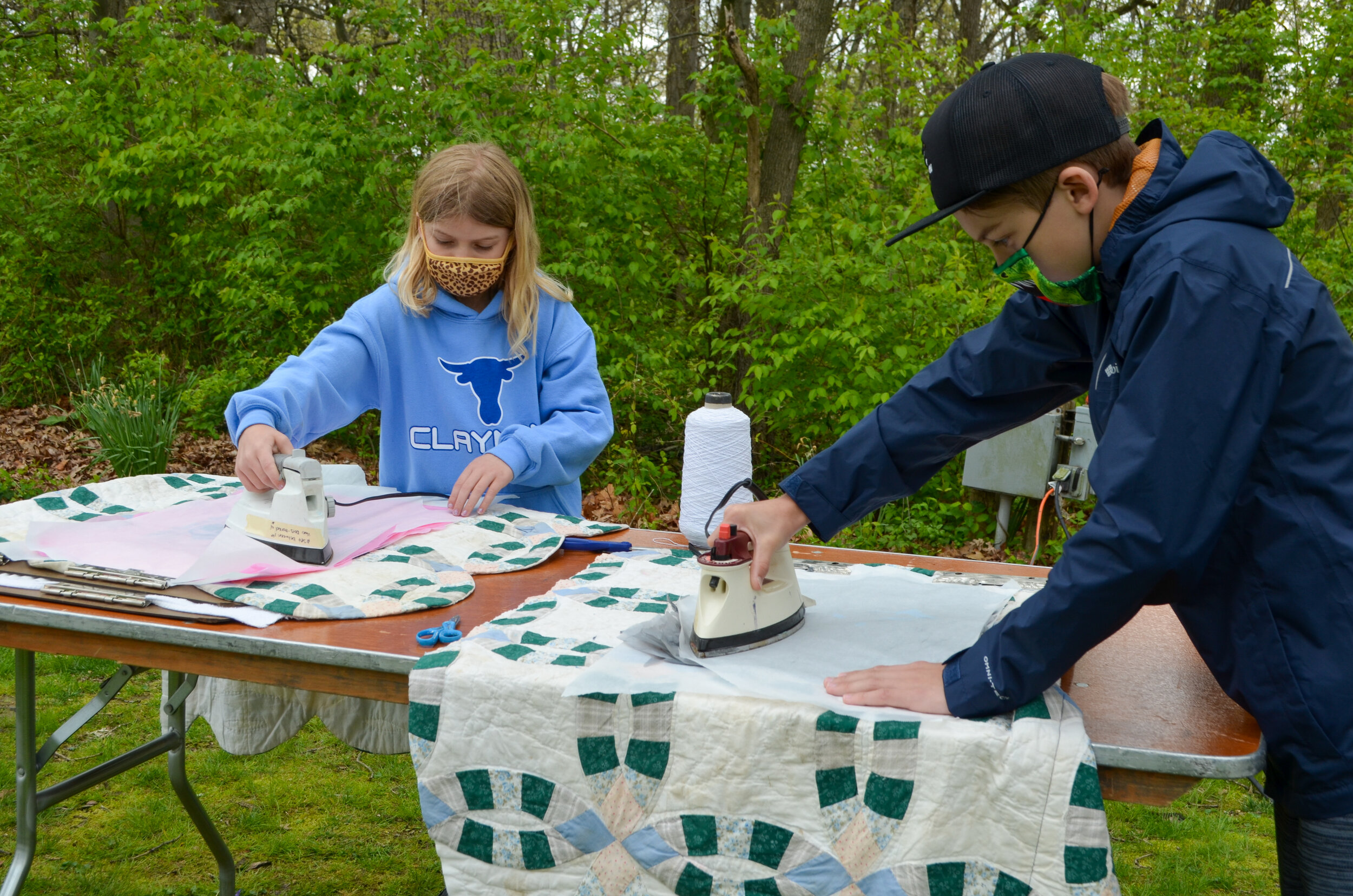  Two kids ironing their fused plastic pouches 