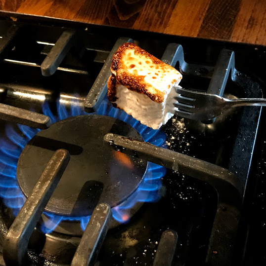 TOAST MARSHMALLOW OVER OPEN FLAME